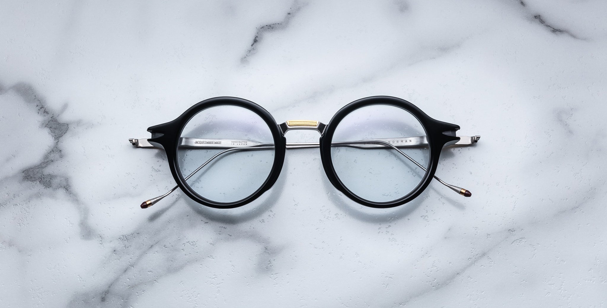 Jacques Marie Mage Norman black-rimmed eyeglasses with clear lenses, top-down view.