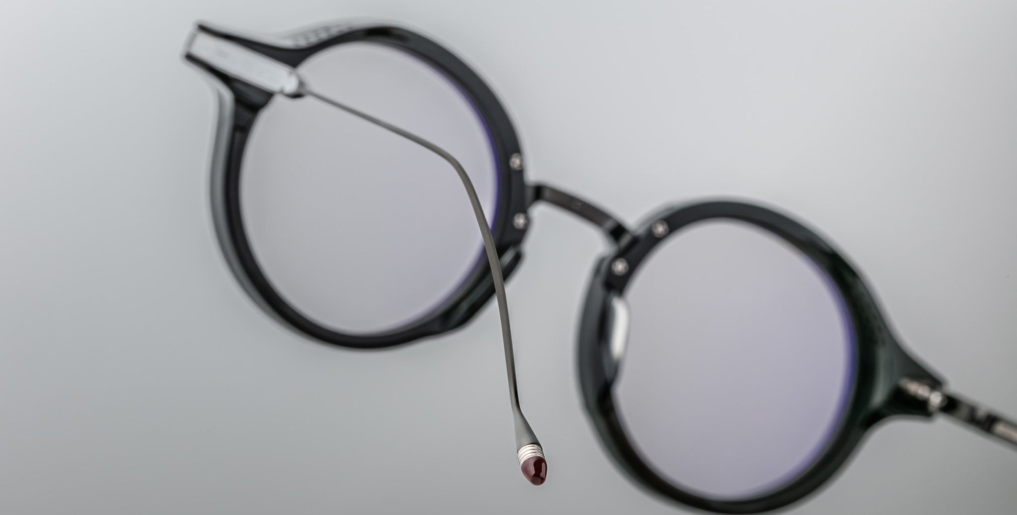 Close-up of Jacques Marie Mage Norman black round eyeglasses, side view showing one extended arm.