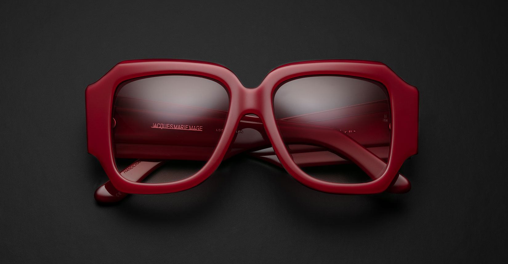 Jacques Marie Mage Gloria sunglasses featuring thick red frames and UV protection, shown from the front angle.