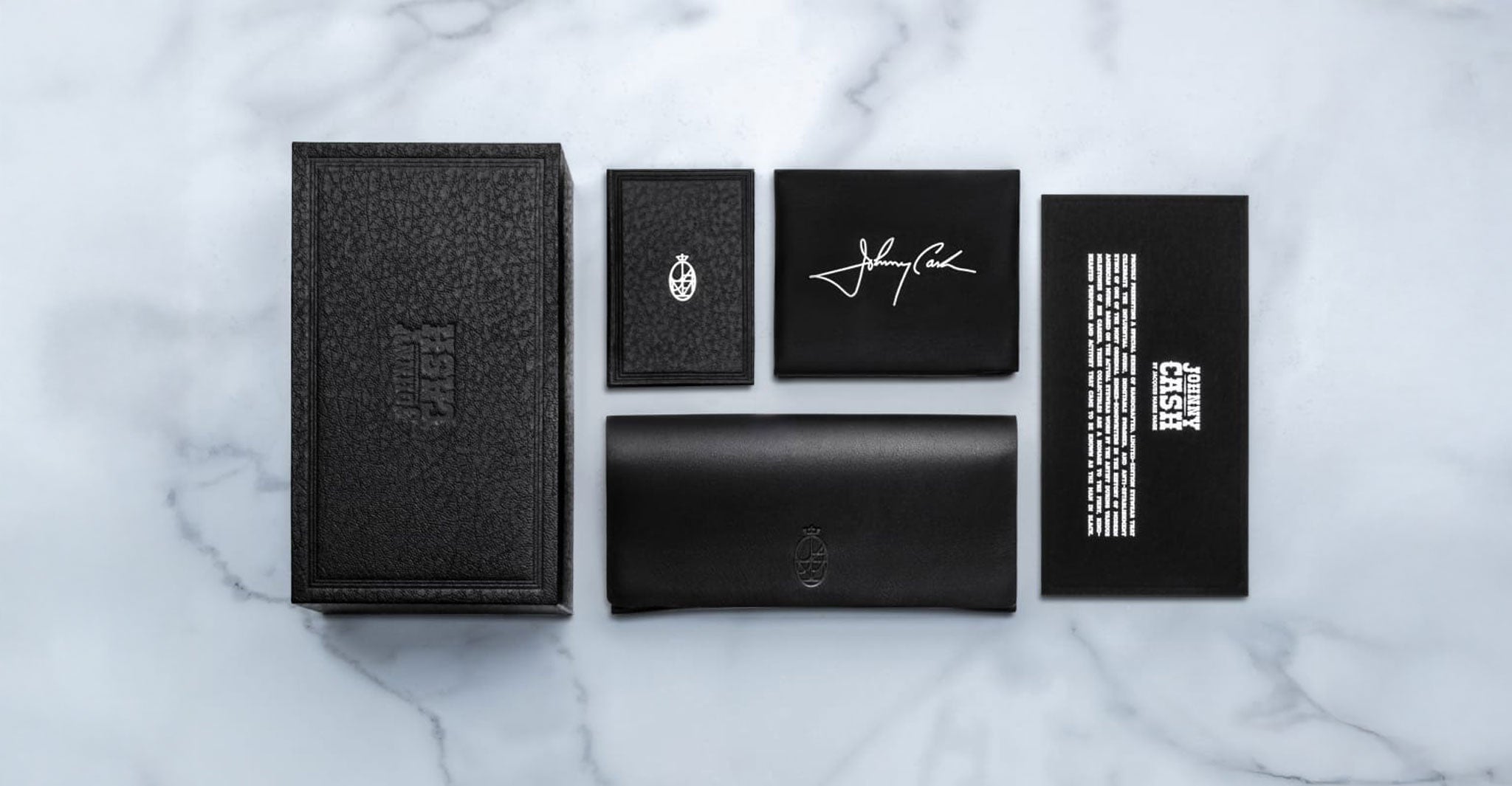 Jacques Marie Mage Quentin black leather wallet and card case, top view. No sunglasses or eyeglasses visible.