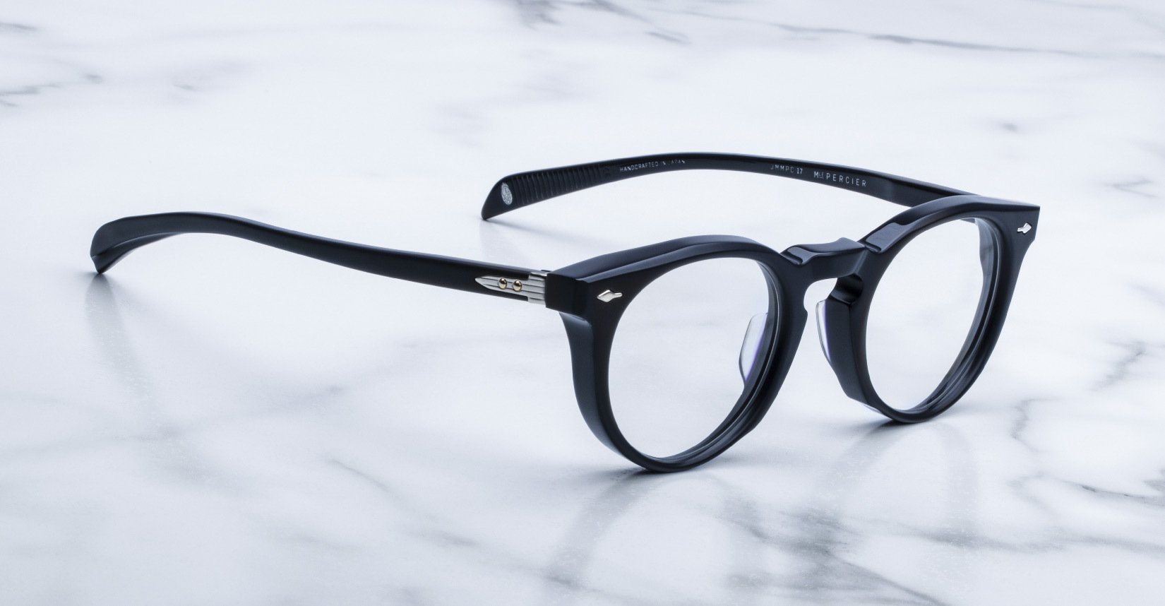 Jacques Marie Mage Percier eyeglasses with clear lenses and round black frames, shown from the front.
