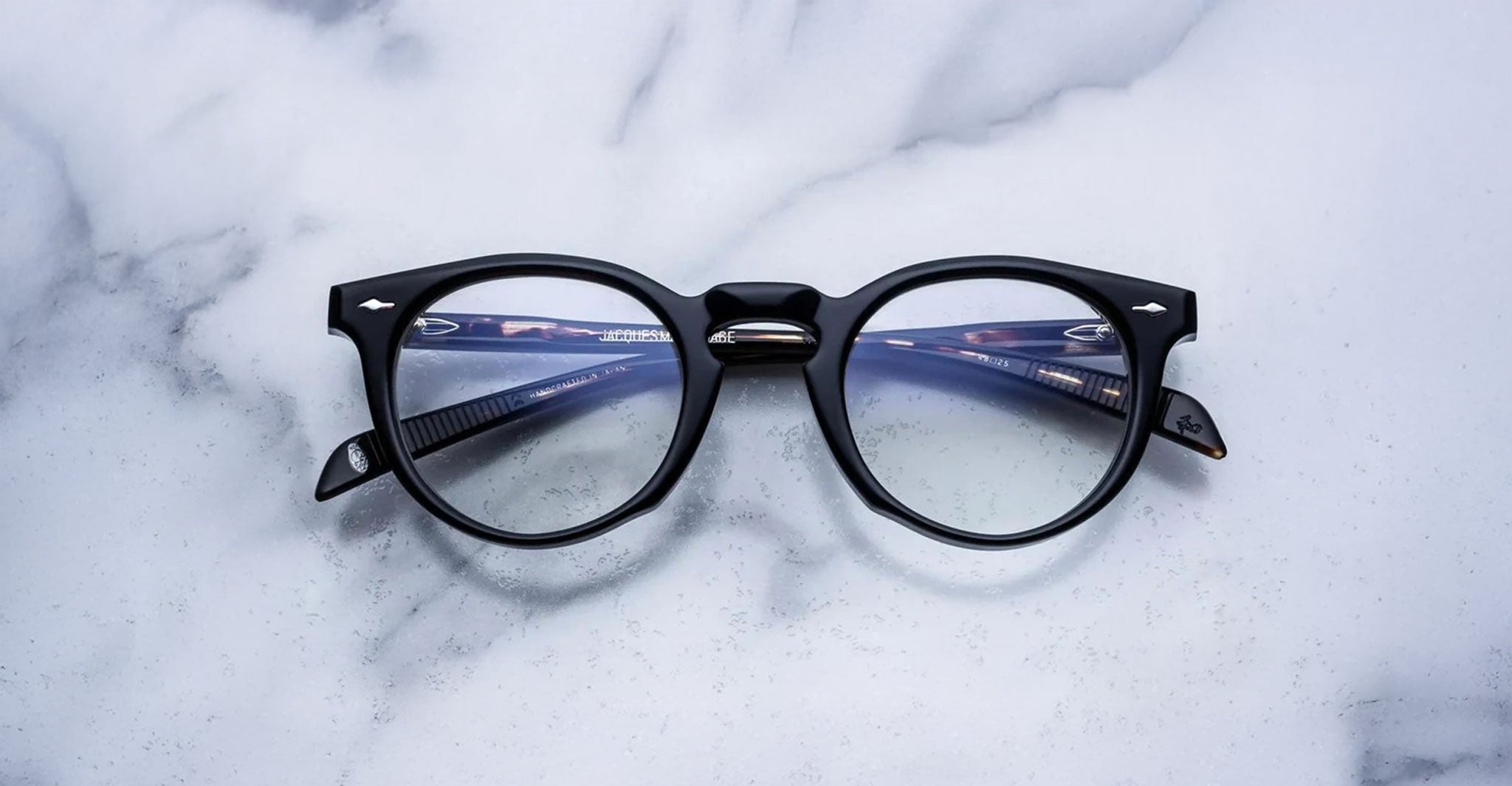 Jacques Marie Mage Percier eyeglasses with clear lenses and black round frames, front view.