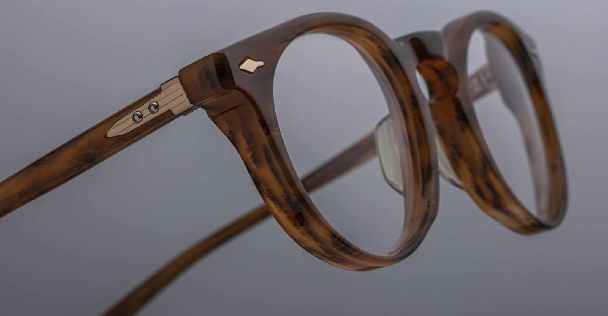 Close-up of Jacques Marie Mage Percier eyeglasses, round tortoiseshell frames, metallic hinges, front angle.