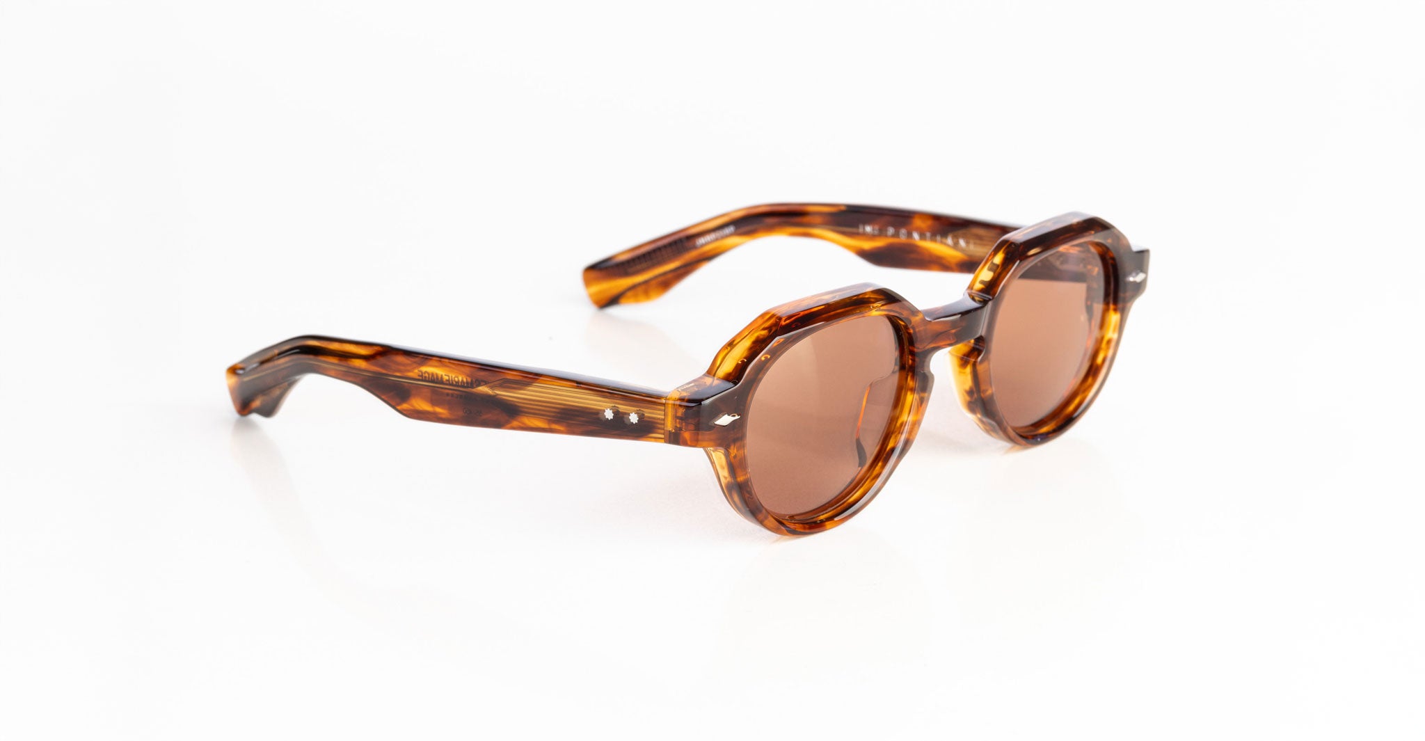 The Jacques Marie Mage Pontian sunglasses, featuring a round tortoiseshell frame and brown tinted lenses, are displayed on a white background.