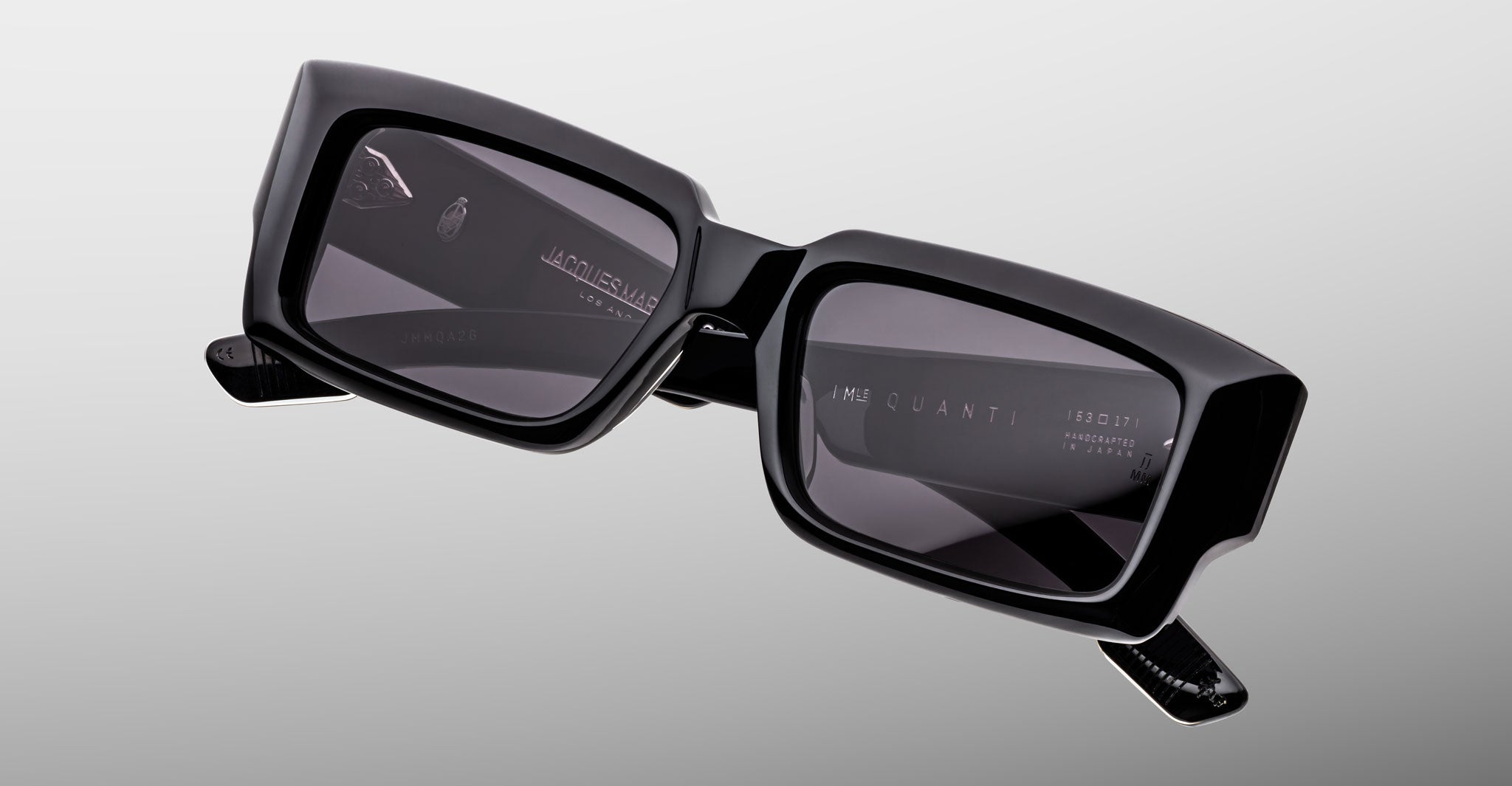 Jacques Marie Mage Quant in Shadow, rectangular black acetate sunglasses shown from a close angled front view, featuring bold sculpted rims, wide temples, and dark tinted lenses.