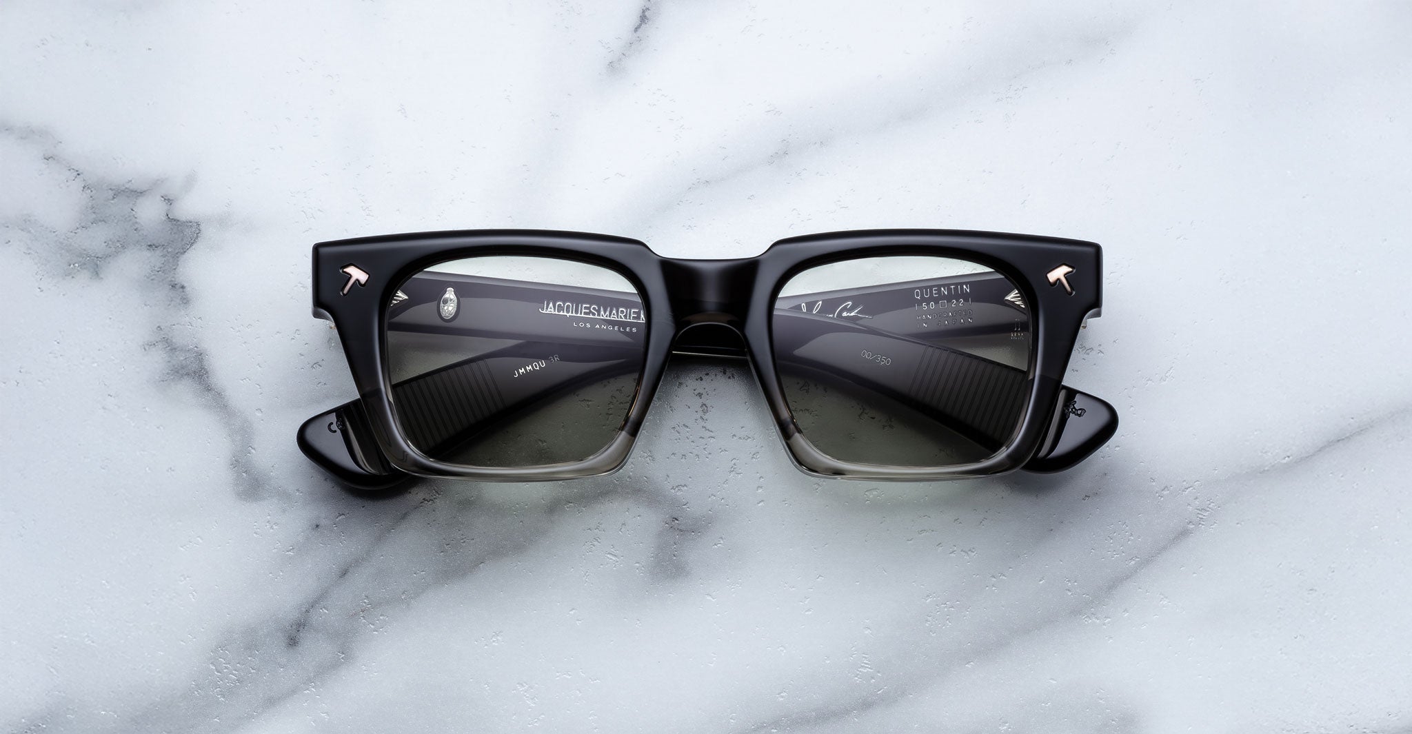 Jacques Marie Mage Quentin black square eyeglasses, brand and model details visible on lenses, shown from above.