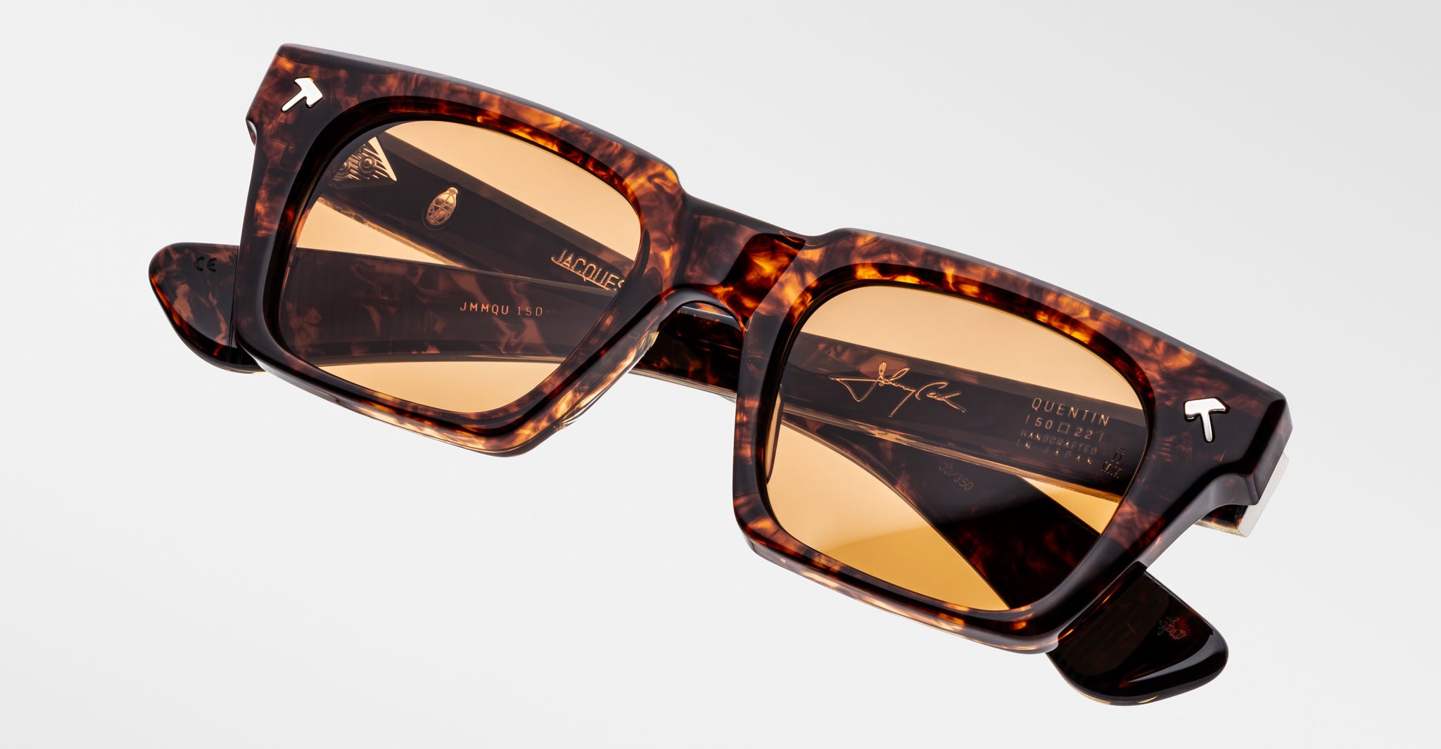 Jacques Marie Mage Quentin sunglasses with tortoiseshell frames, amber lenses, and visible brand logos on the arms, side view.