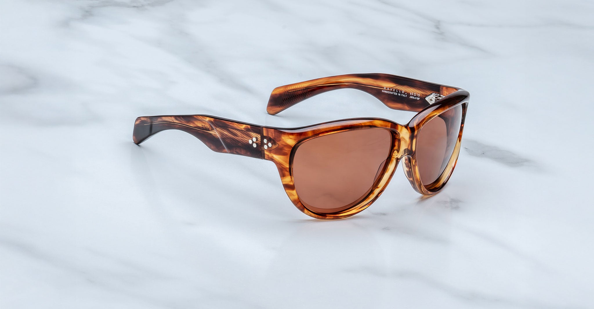 Jacques Marie Mage Ravello sunglasses featuring thick brown tortoiseshell frames and brown tinted lenses, displayed on a white marble surface.