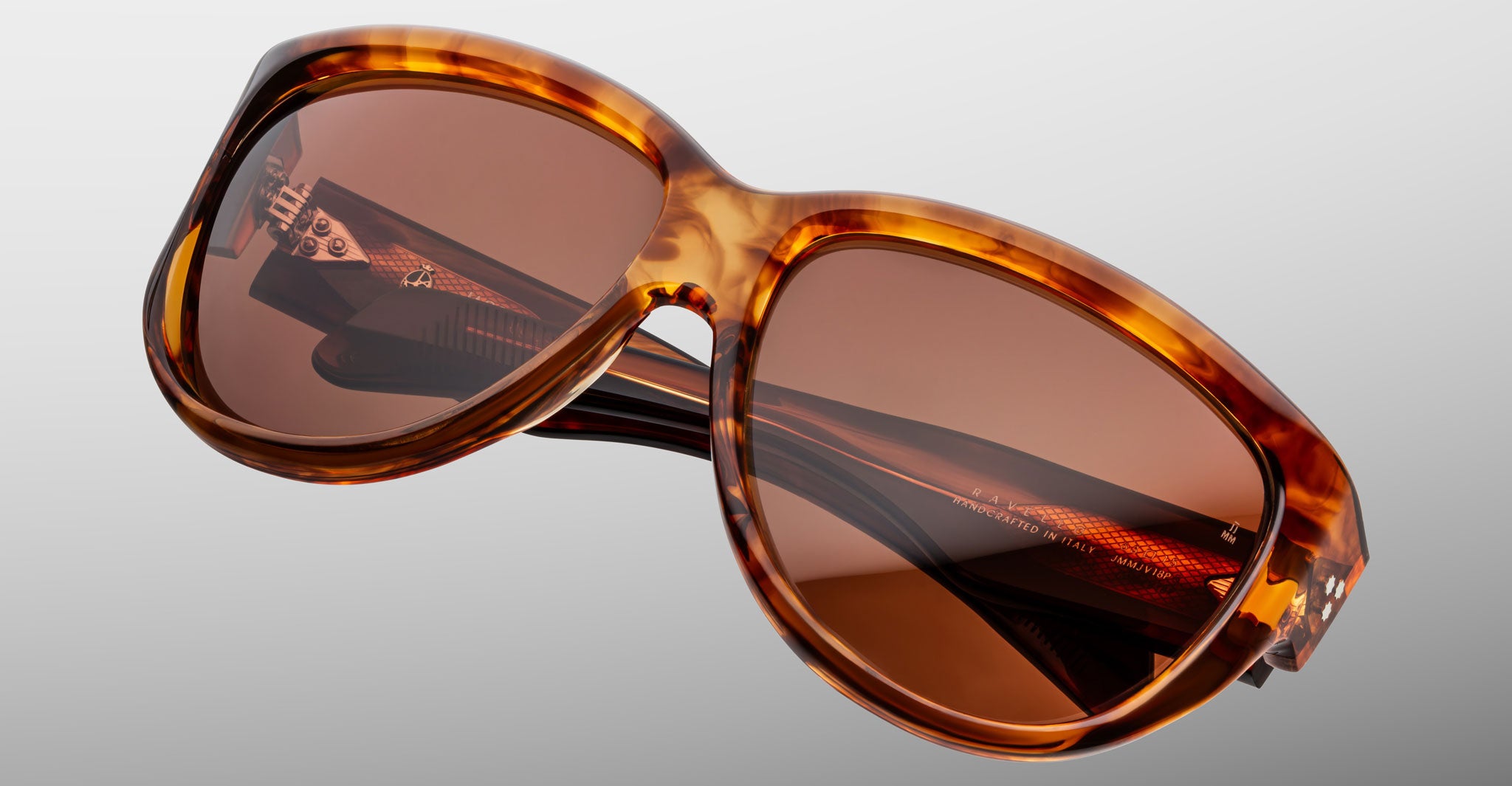 Close-up of Jacques Marie Mage Ravello oversized sunglasses, featuring a tortoiseshell frame and brown-tinted lenses, set against a light gray background.