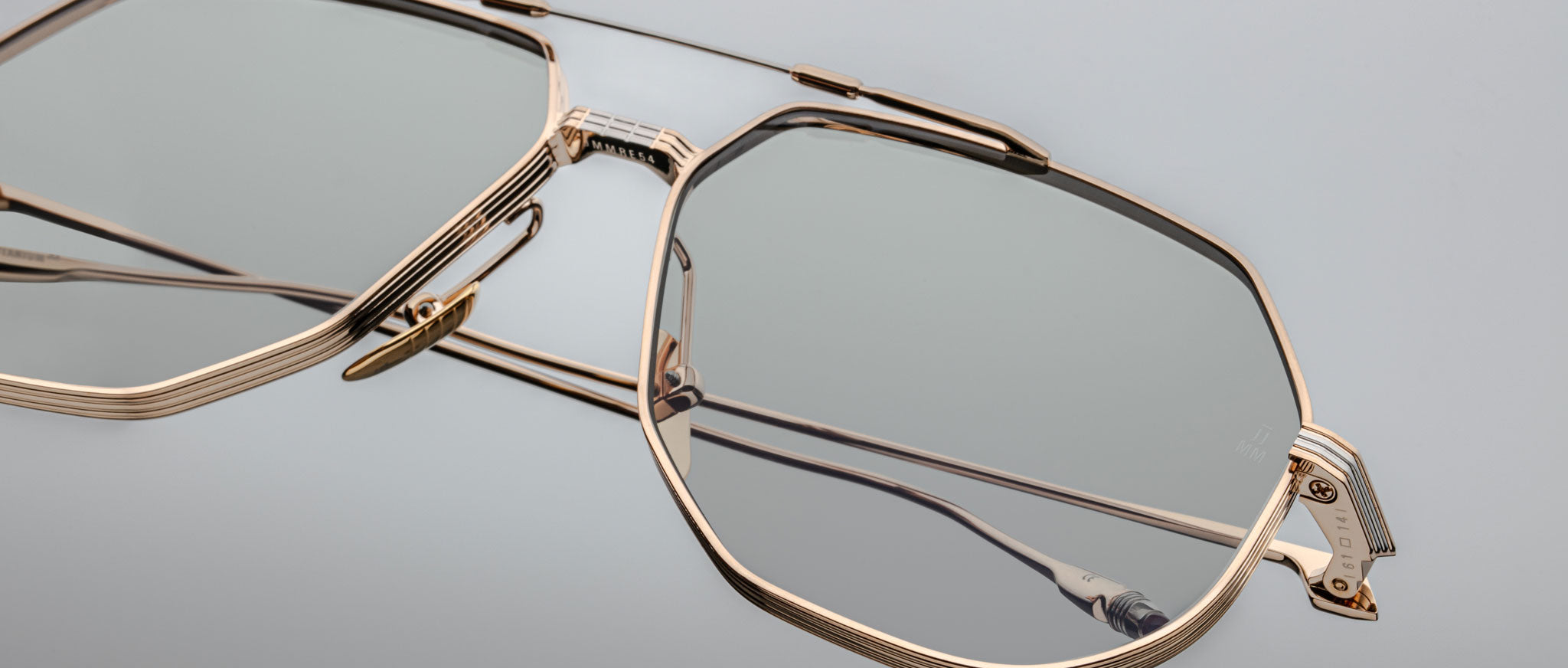 Close-up of Jacques Marie Mage Reynold geometric gold eyeglasses with clear lenses, front view.