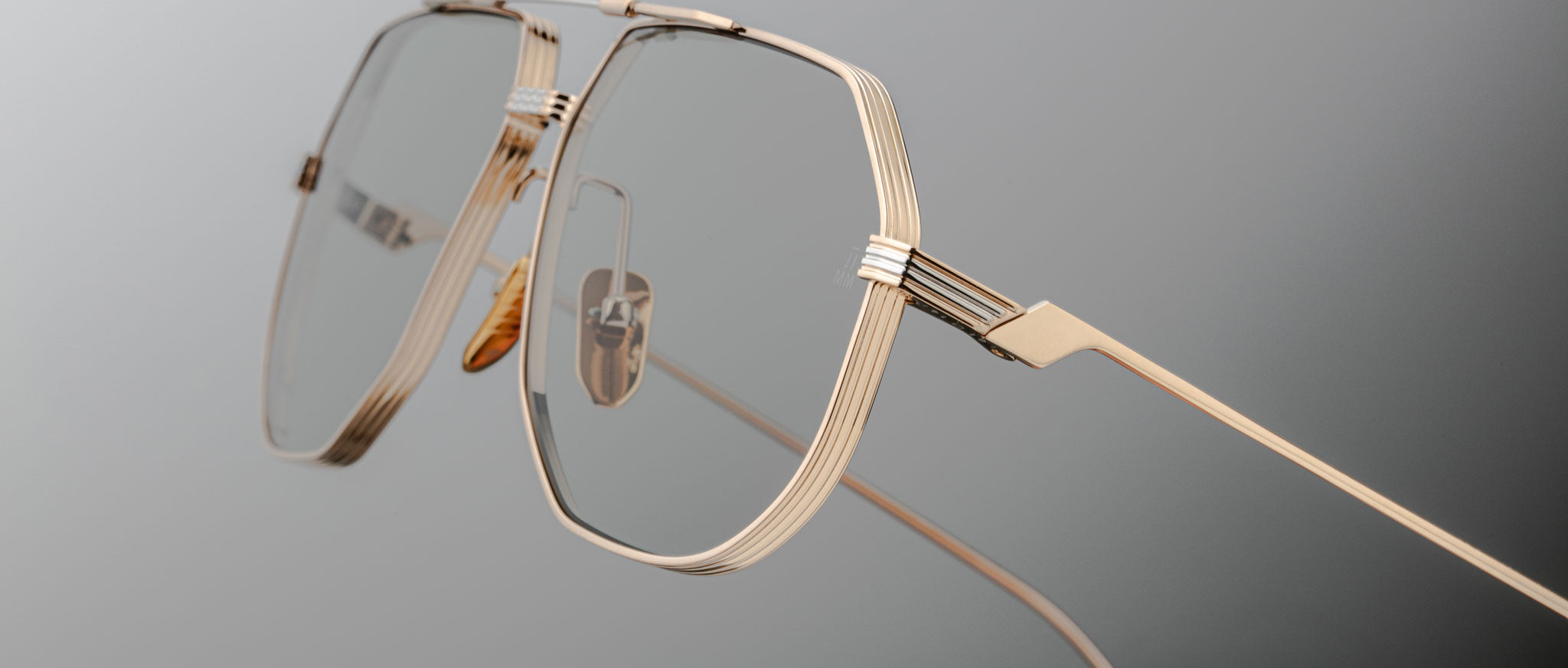 Close-up of Jacques Marie Mage Reynold gold wire-frame eyeglasses showing unique detailing, viewed from the front.