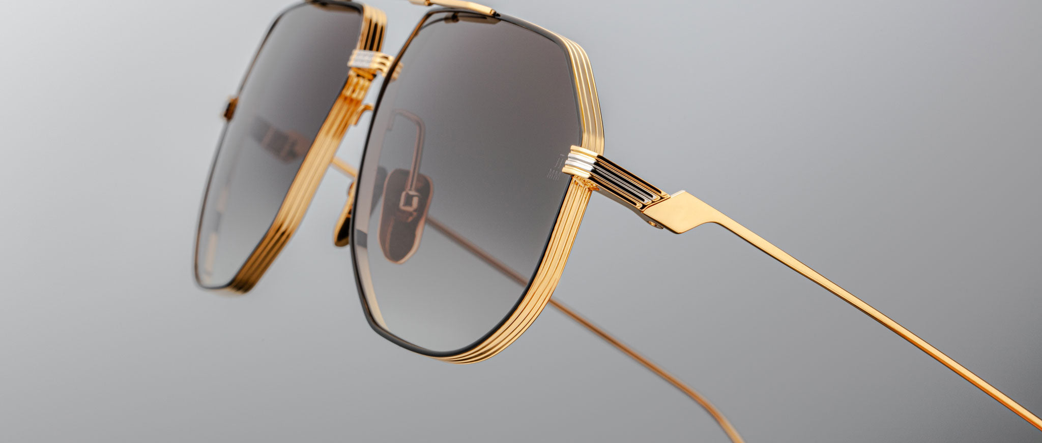 Close-up of Jacques Marie Mage Reynold aviator sunglasses with gold rims and tinted lenses, front-facing view.