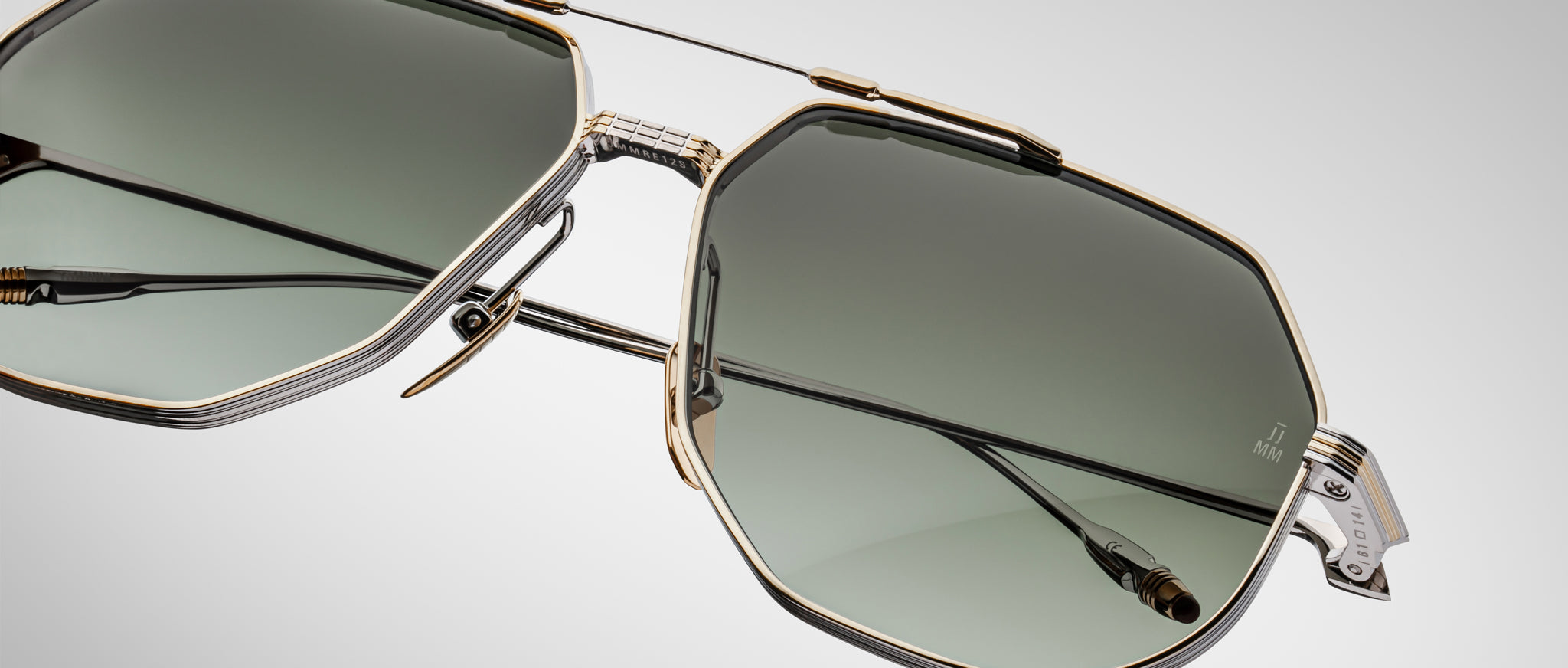 Close-up of Jacques Marie Mage Reynold aviator sunglasses featuring green lenses and gold-toned metal frames.