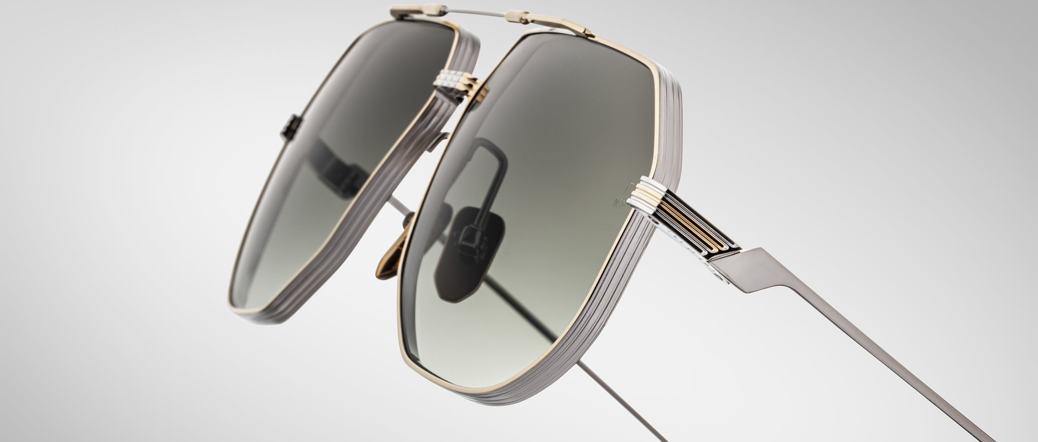 Close-up view of Jacques Marie Mage Reynold geometric sunglasses featuring dark lenses and metallic frames.