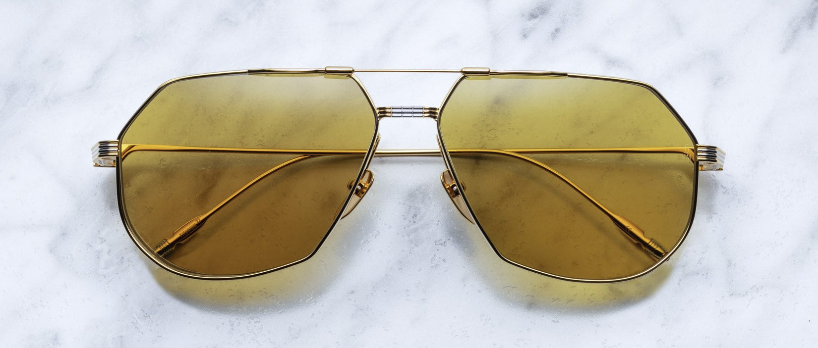 Jacques Marie Mage Reynold aviator sunglasses in gold with yellow lenses, shown from above.