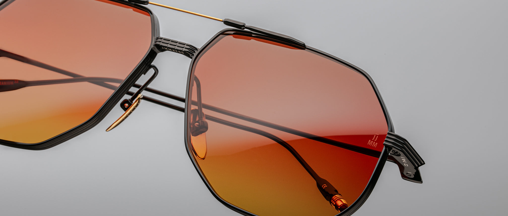 Jacques Marie Mage Reynold sunglasses, geometric black frame with UV-protective orange gradient lenses, front view.