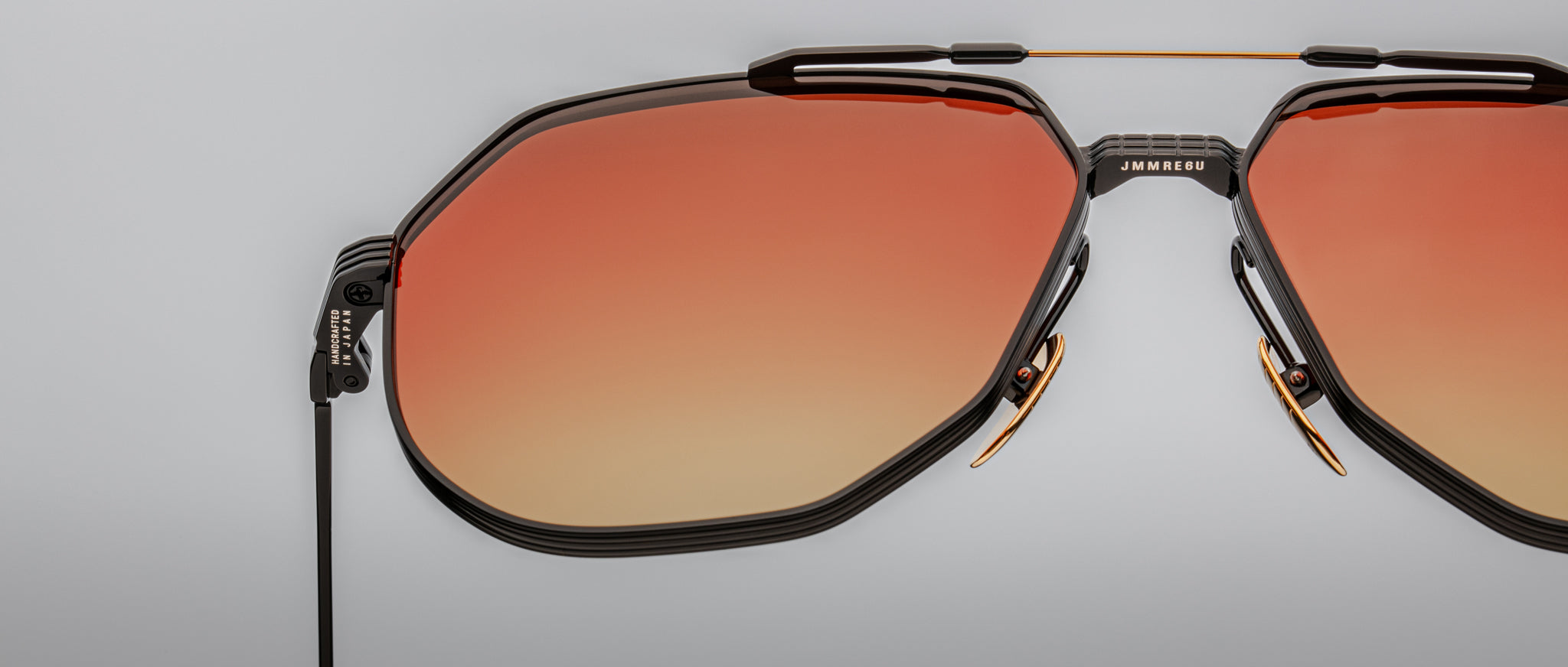 Jacques Marie Mage Reynold sunglasses with geometric black frame and UV-protection orange gradient lenses, front view.