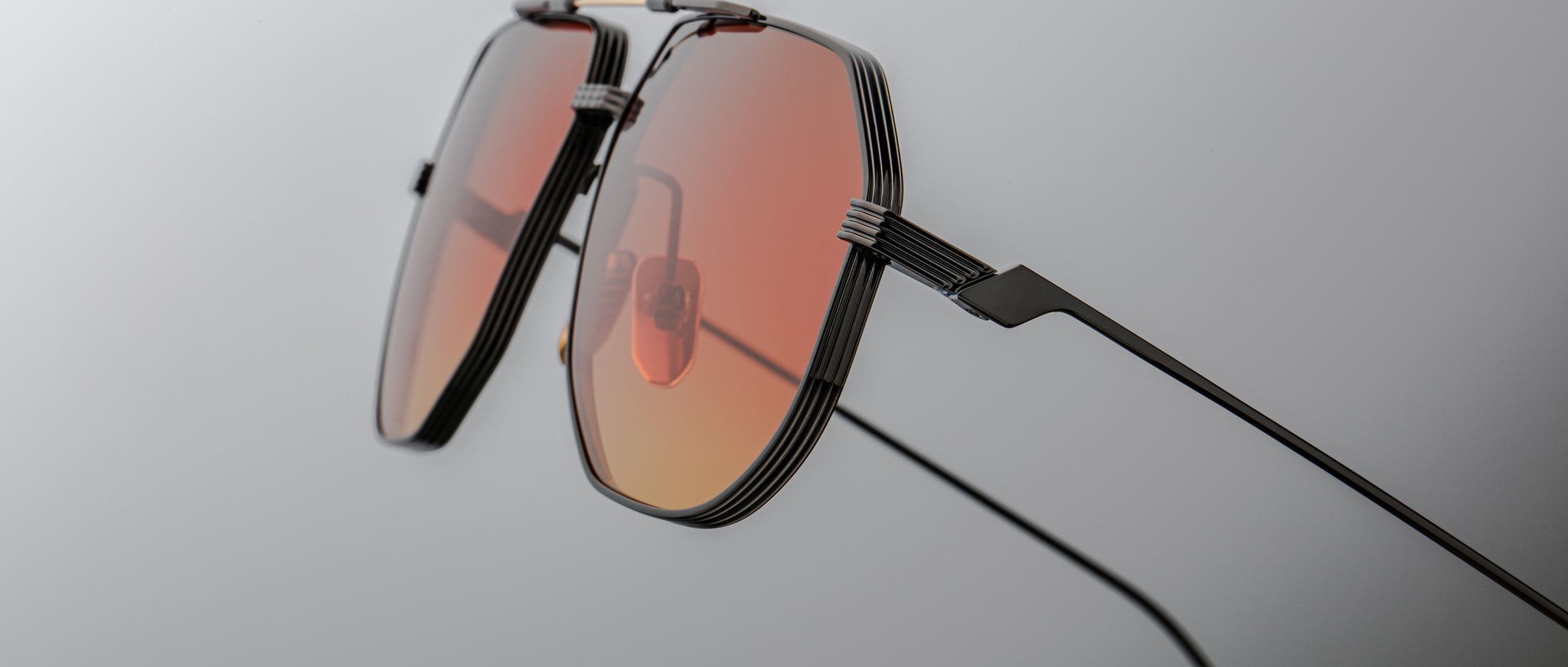 Close-up of Jacques Marie Mage Reynold sunglasses, featuring red tinted lenses and thin black frames, front-facing angle.