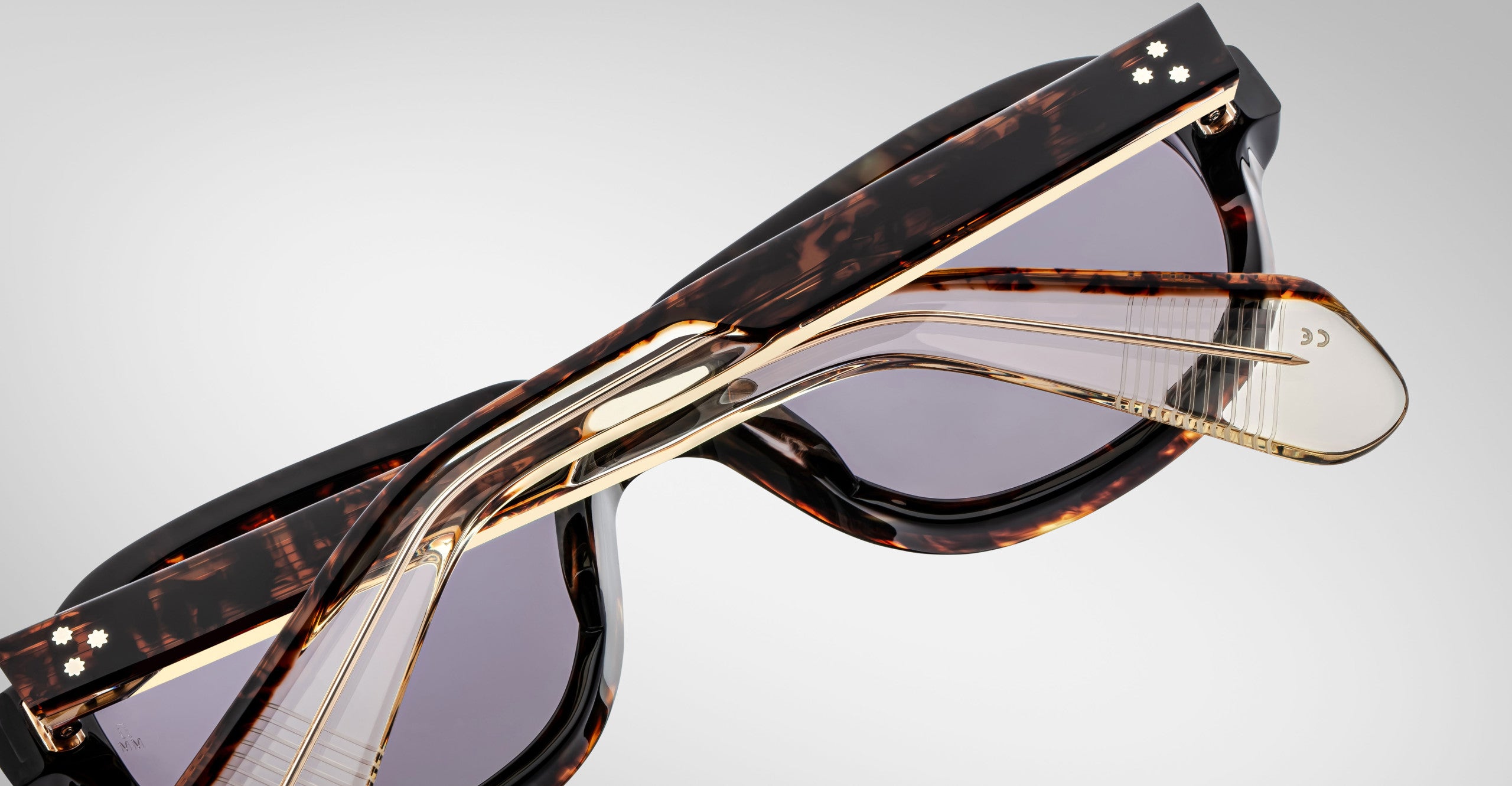 Detailed back view of a pair of Jacques Marie Mage Richard Havana, thick-framed sunglasses with blue lenses on a plain background
