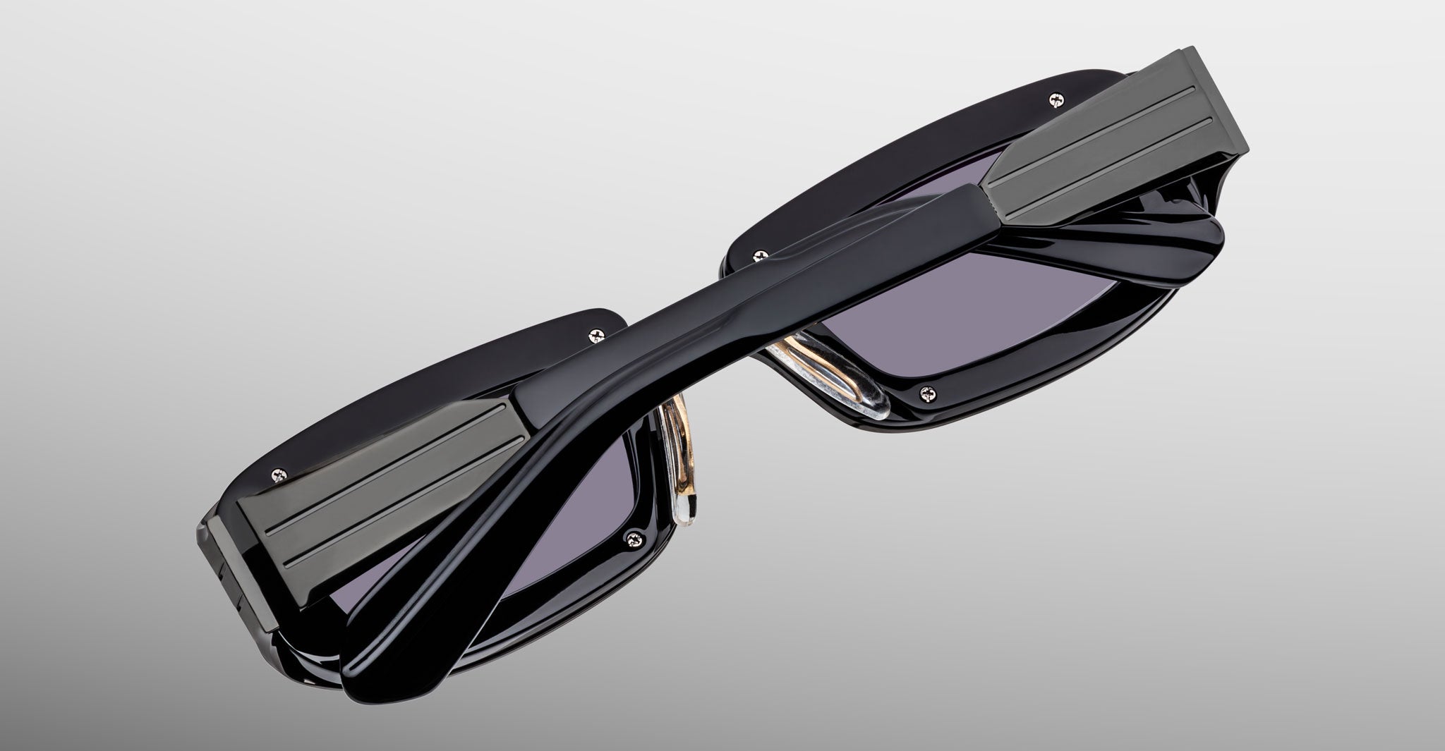 Jacques Marie Mage Ryder in Black, rectangular black acetate sunglasses shown from an angled top view, highlighting thick sculpted rims, wide temples with stepped detailing, and dark tinted lenses.