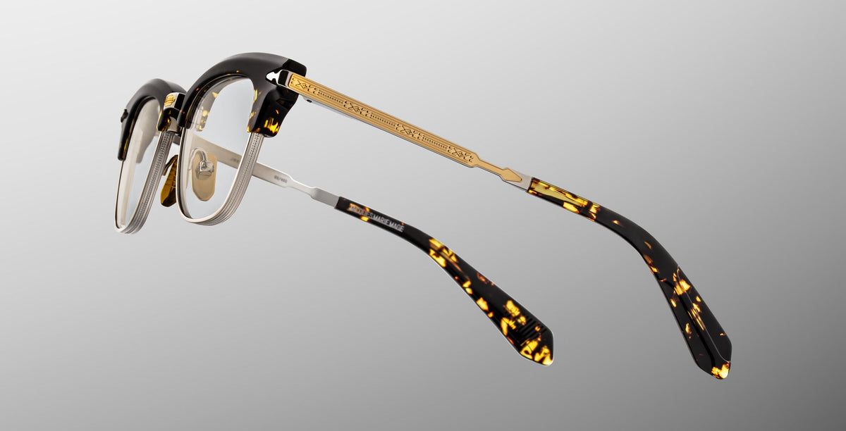 The Jacques Marie Mage Sartre glasses feature gold metal arms and tortoiseshell clubmaster frames, displayed from the rear against a gray gradient background.