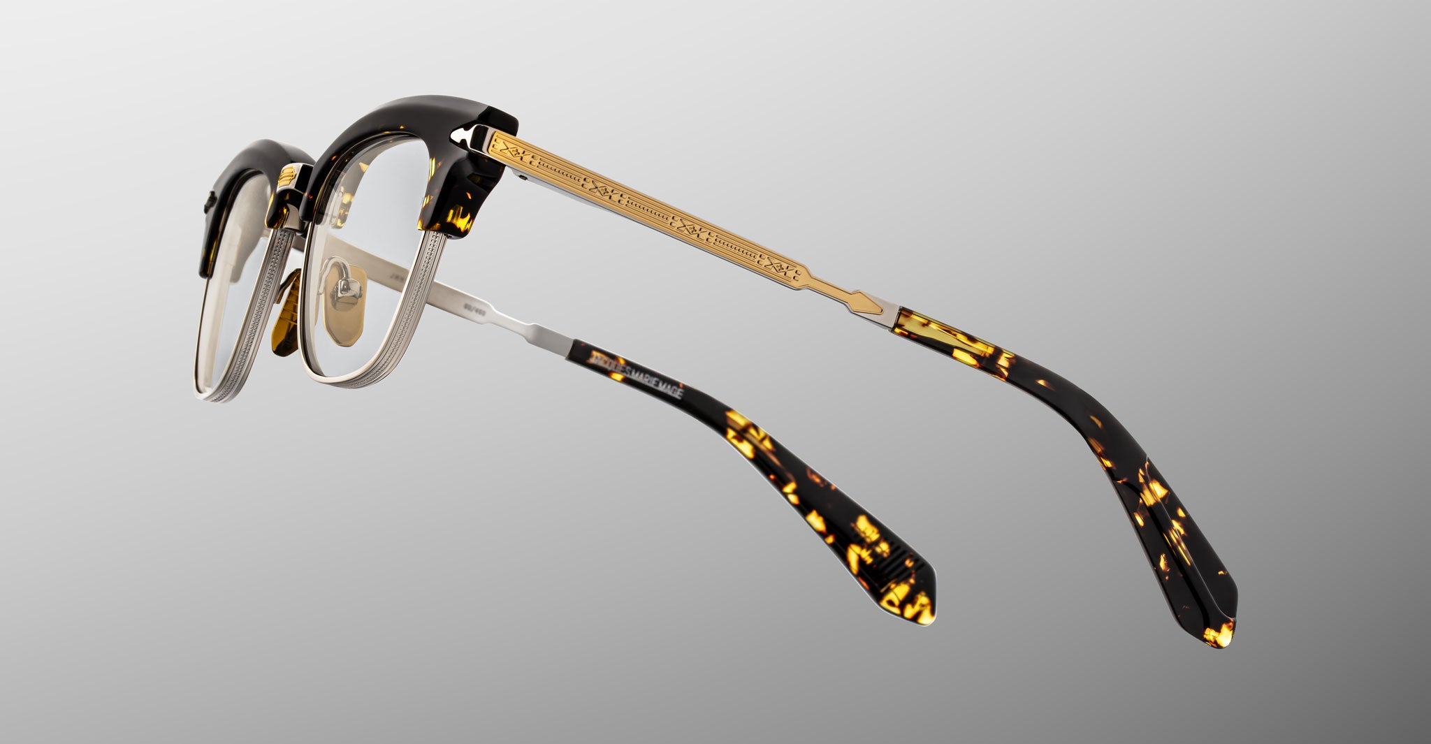 The Jacques Marie Mage Sartre glasses feature gold metal arms and tortoiseshell clubmaster frames, displayed from the rear against a gray gradient background.