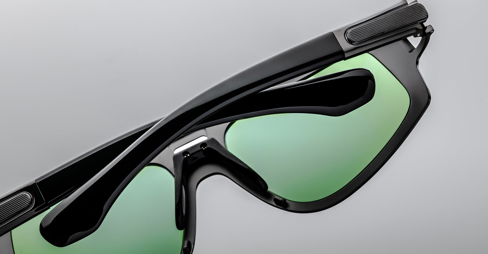 Close-up of Jacques Marie Mage Scarface sunglasses, black frame with green-tinted lenses, front angle view.