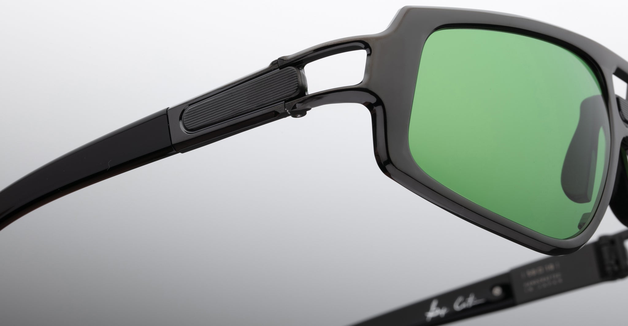 Close-up of Jacques Marie Mage Scarface sunglasses, polarized green lenses, with visible hinge and temple details.
