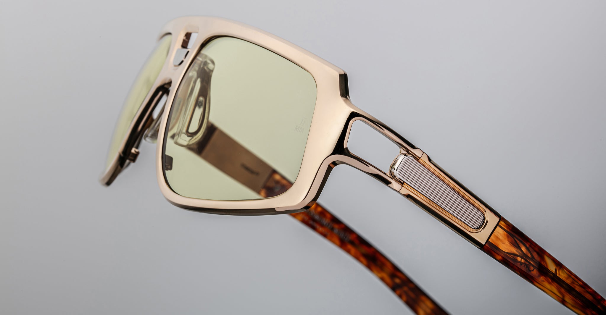 Close-up of Jacques Marie Mage Scarface sunglasses featuring gold square frames, yellow lenses, and brown marbled arms.