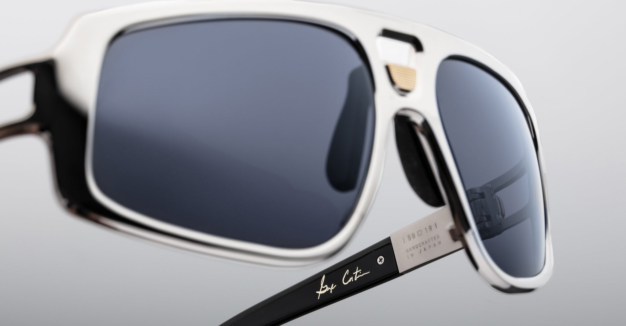 Close-up of Jacques Marie Mage Scarface sunglasses, black and white, dark lenses, designer detail on temples, front angle view.