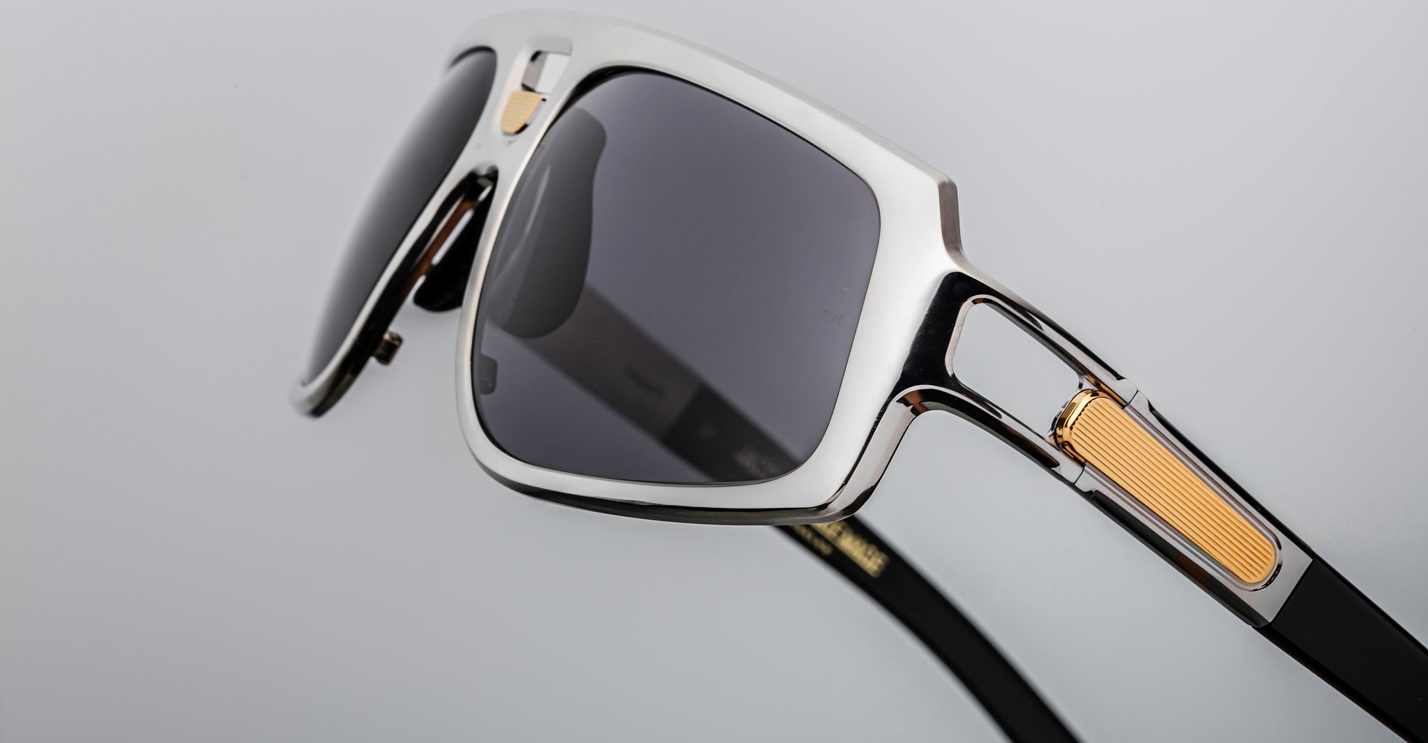 Jacques Marie Mage Scarface sunglasses with black lenses, silver frame, and gold temple accents shown from the front.