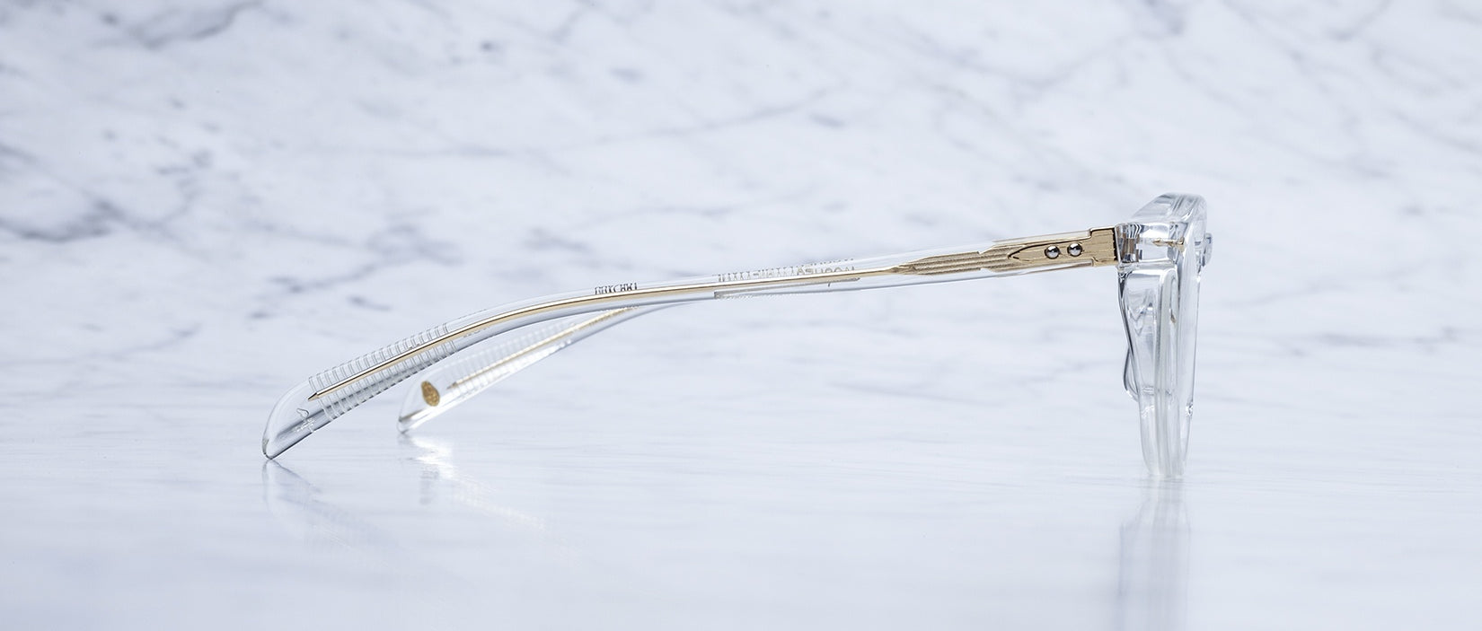 Jacques Marie Mage Sheridan in Clear, crystal acetate glasses with visible wirecore temples and gold hardware, side view