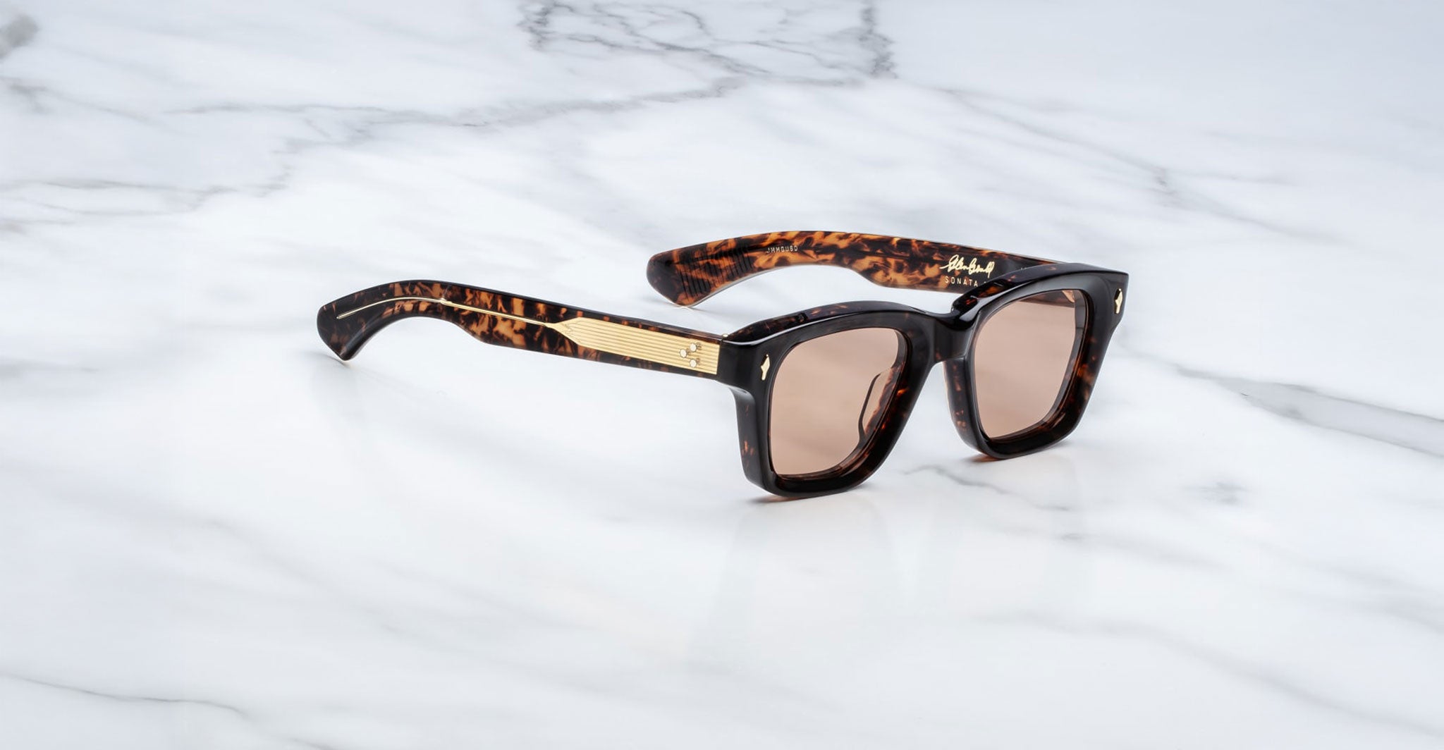 Jacques Marie Mage Sonata sunglasses, gold accents, UV-protected brown lenses, shown from above.