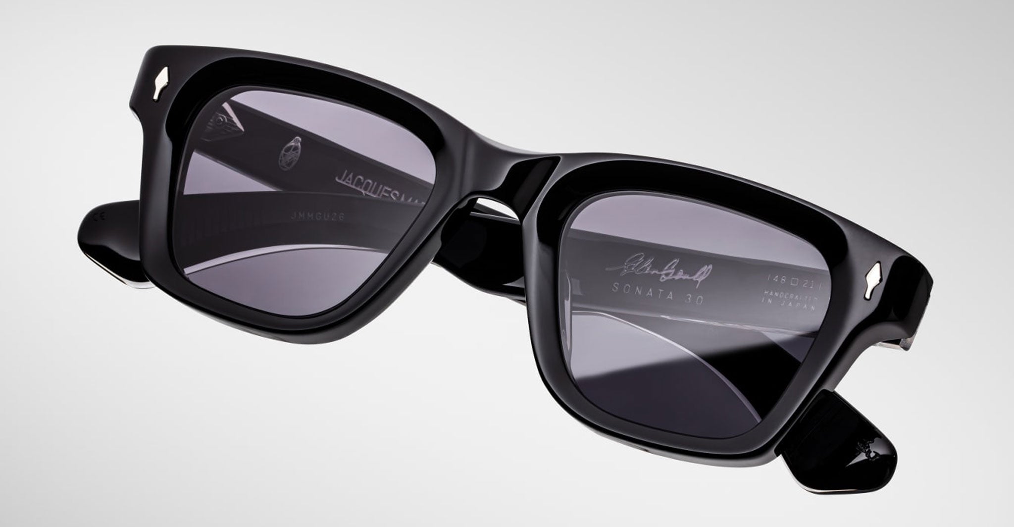Jacques Marie Mage Sonata sunglasses, front view: black square frames, dark lenses, engraved logo on arms and lens.