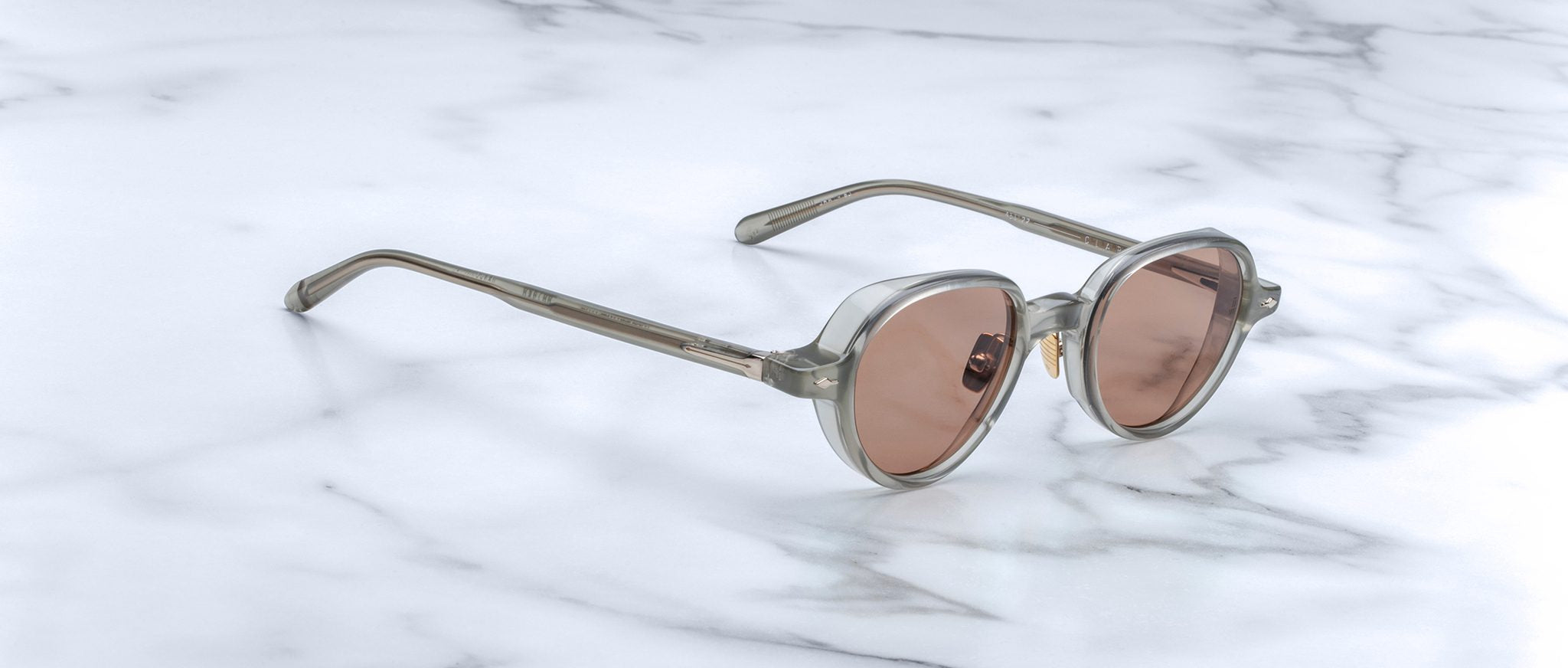 Jacques Marie Mage The Clark sunglasses feature light brown frames and pink lenses, shown from above.