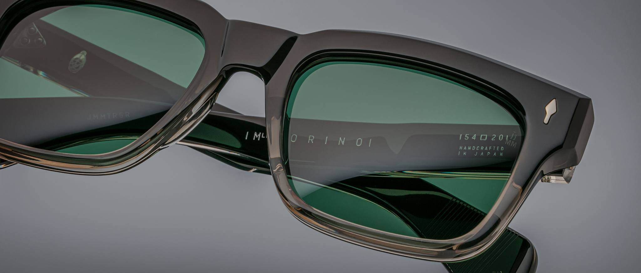 Close-up of Jacques Marie Mage Torino rectangular frames in green-tinted acetate, highlighting detailed text and expert craftsmanship on the temple and lens—a hallmark of Jacques Marie Mage handcrafted eyewear.