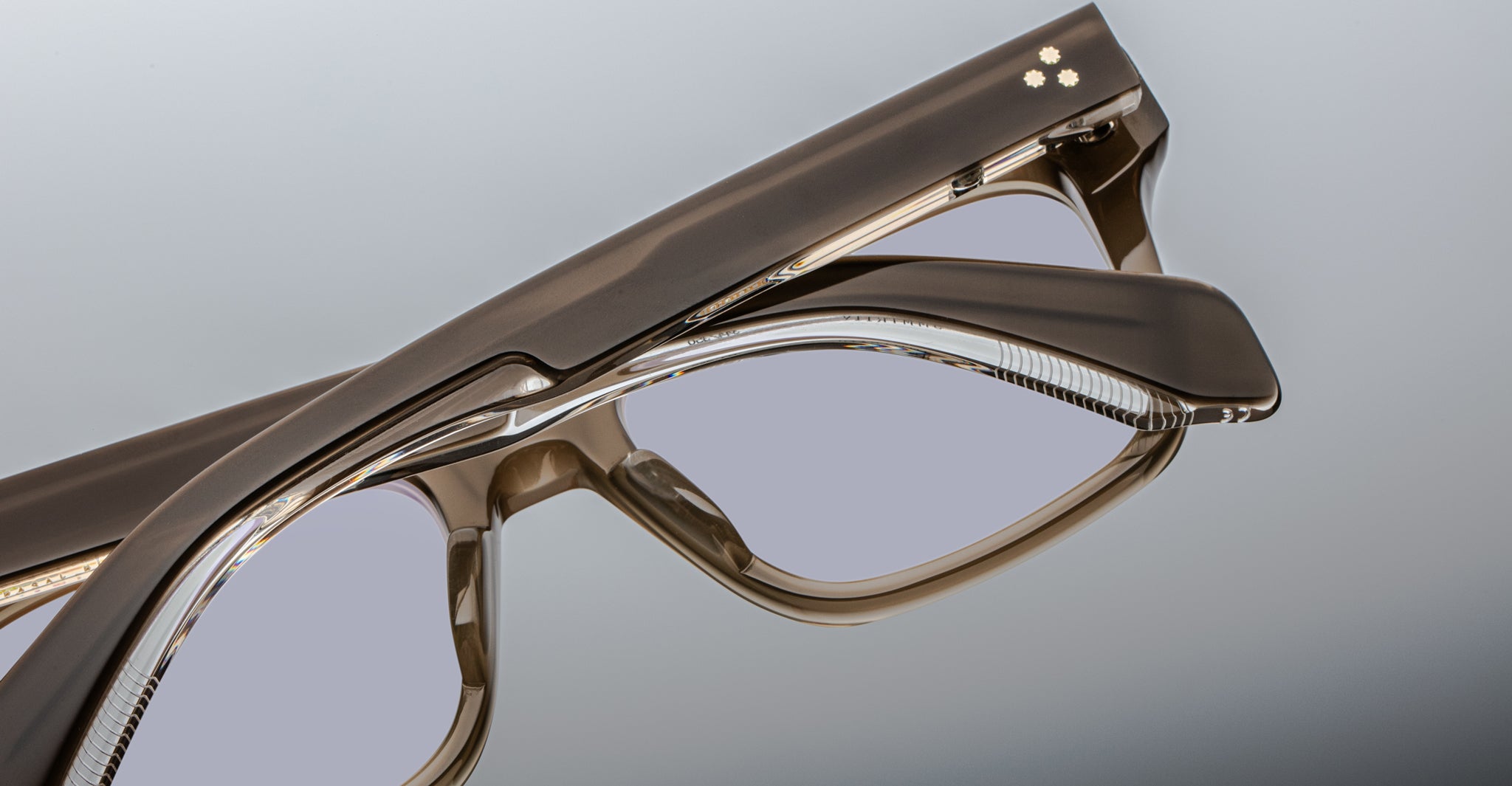 Close-up of Jacques Marie Mage Torino eyeglasses by Jacques Marie Mage, showcasing bold rectangular frames in glossy handcrafted acetate with clear lenses, displayed against a neutral background.
