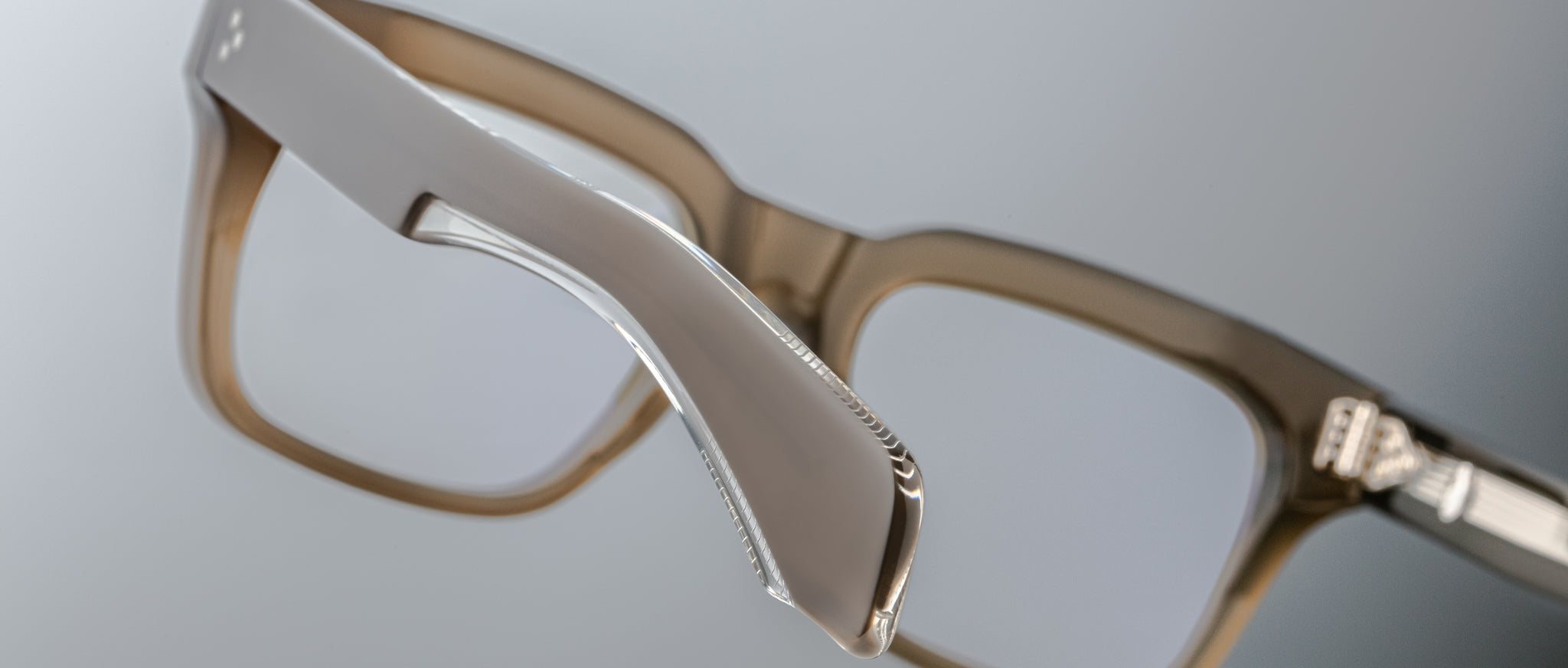 Close-up of Jacques Marie Mage Torino eyeglass frames by Jacques Marie Mage, highlighting the handcrafted acetate frame and hinge against a neutral background.