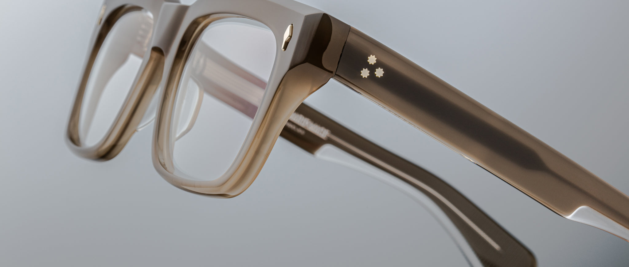 Close-up of Jacques Marie Mage Torino eyeglasses: bold rectangular frames in transparent handcrafted acetate with thick temples and two decorative dots, showcasing Jacques Marie Mage’s distinctive style.