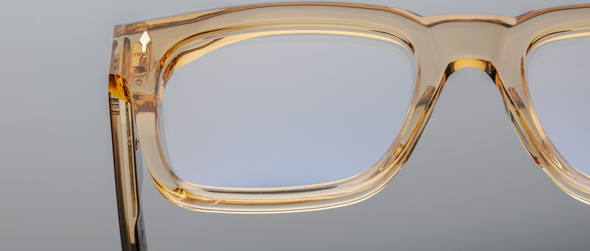 Close-up of the Jacques Marie Mage Torino: bold, handcrafted rectangular eyeglass frames in light brown acetate, set against a neutral background.