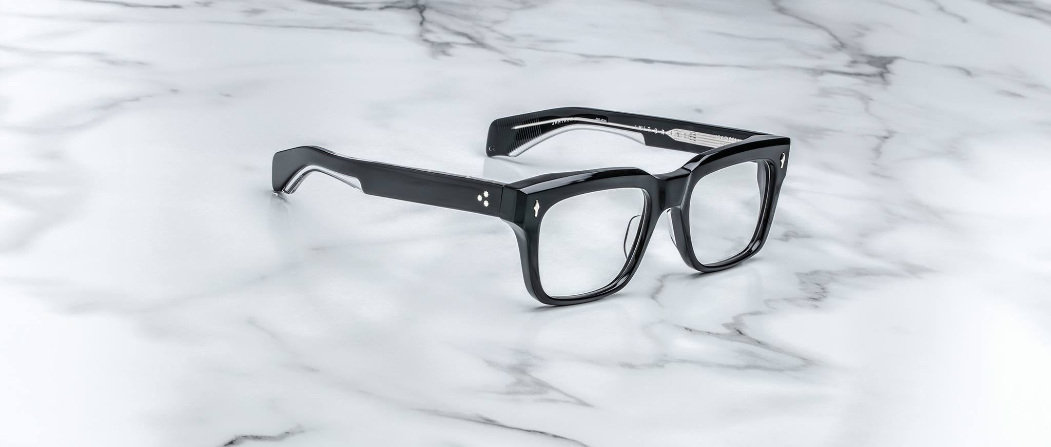 Jacques Marie Mage Torino bold rectangular eyeglass frames, handcrafted in acetate by Jacques Marie Mage, are displayed elegantly on a white marble surface with gray veining.