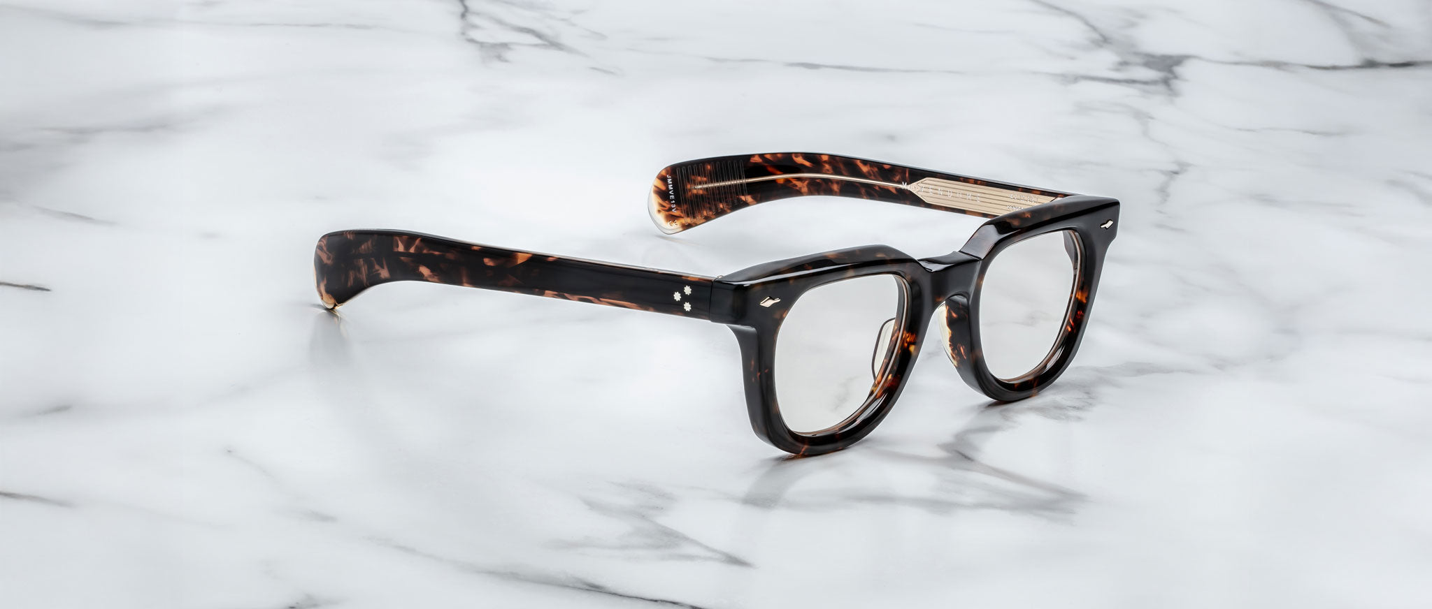 Jacques Marie Mage Vendome eyeglasses, top-down view, feature acetate frames displayed on a white marble desk.