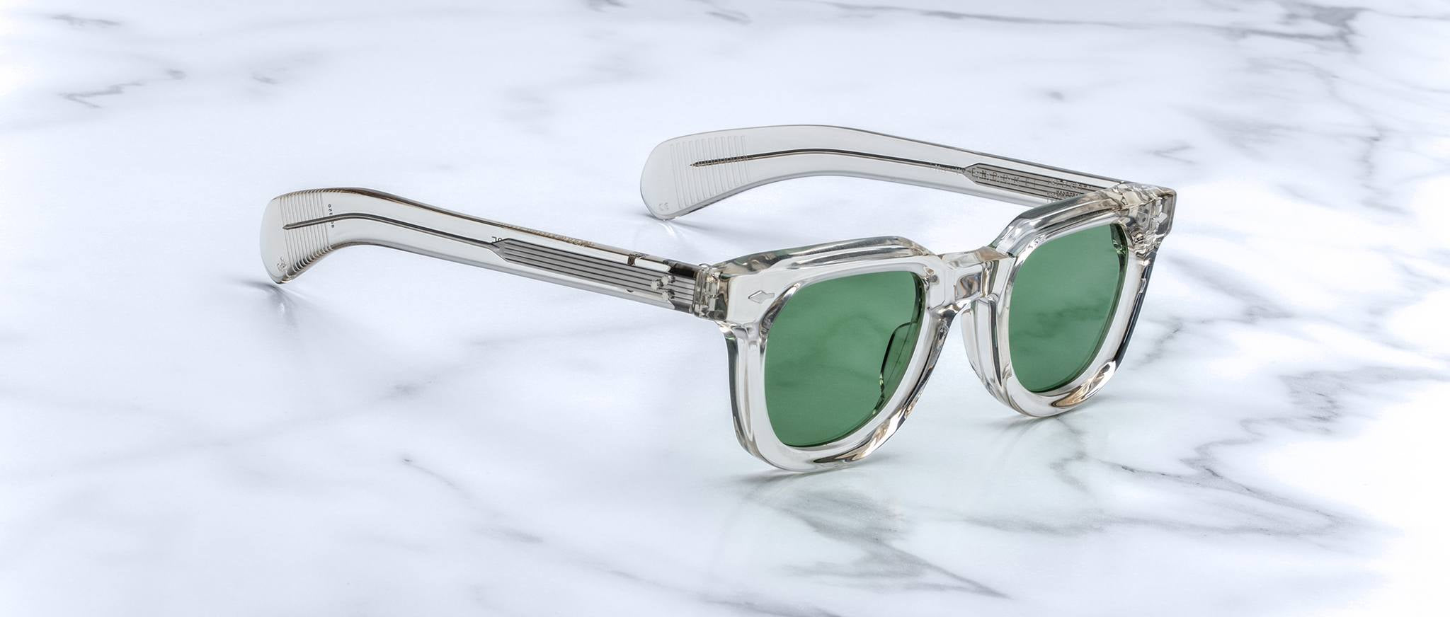 Jacques Marie Mage Vendome clear-framed sunglasses with green lenses viewed from above.