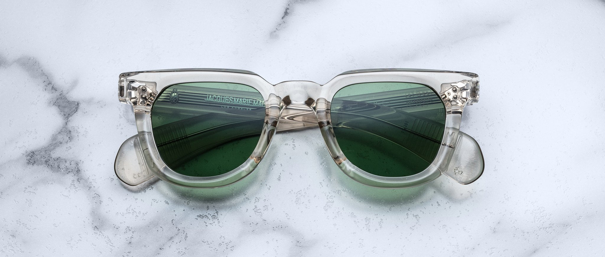 Jacques Marie Mage Vendome clear frame sunglasses with green lenses, front angle.