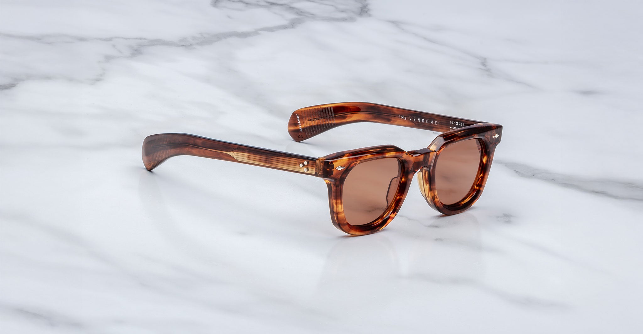 Jacques Marie Mage Vendome sunglasses by Jacques Marie Mage, handcrafted in Japan with tortoiseshell frames and brown lenses, displayed on a white marble surface.