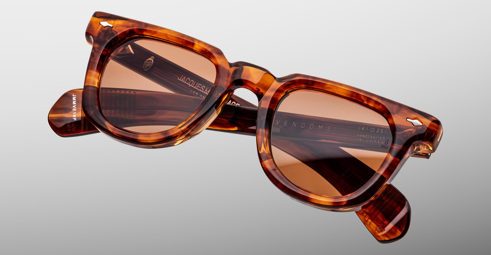 Jacques Marie Mage Vendome tortoiseshell rectangular sunglasses with brown tinted lenses, handcrafted in Japan, are displayed against a light gray background.