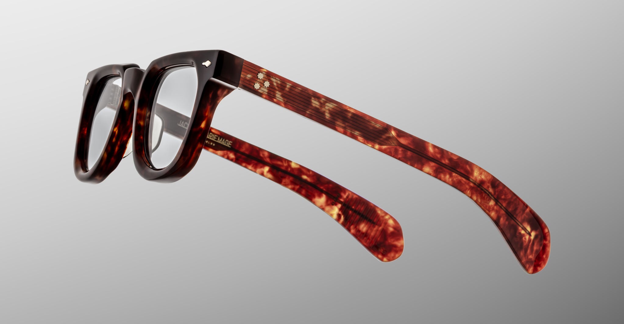 The Jacques Marie Mage Vendome optical frames by Jacques Marie Mage, handcrafted in Japan, feature thick rectangular tortoiseshell rims and clear lenses, shown on a light gray gradient background.