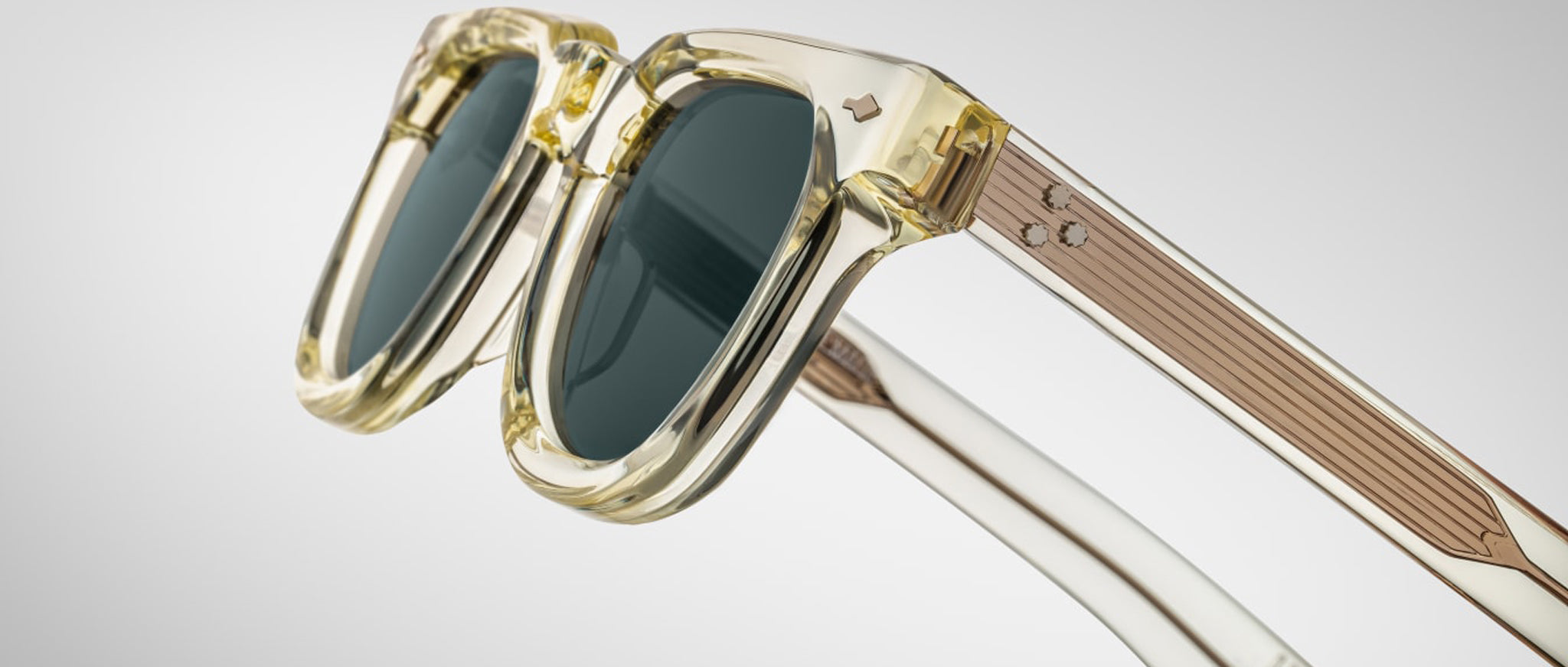 Jacques Marie Mage Vendome sunglasses with clear frames, dark lenses, and tan arms shown from the front.