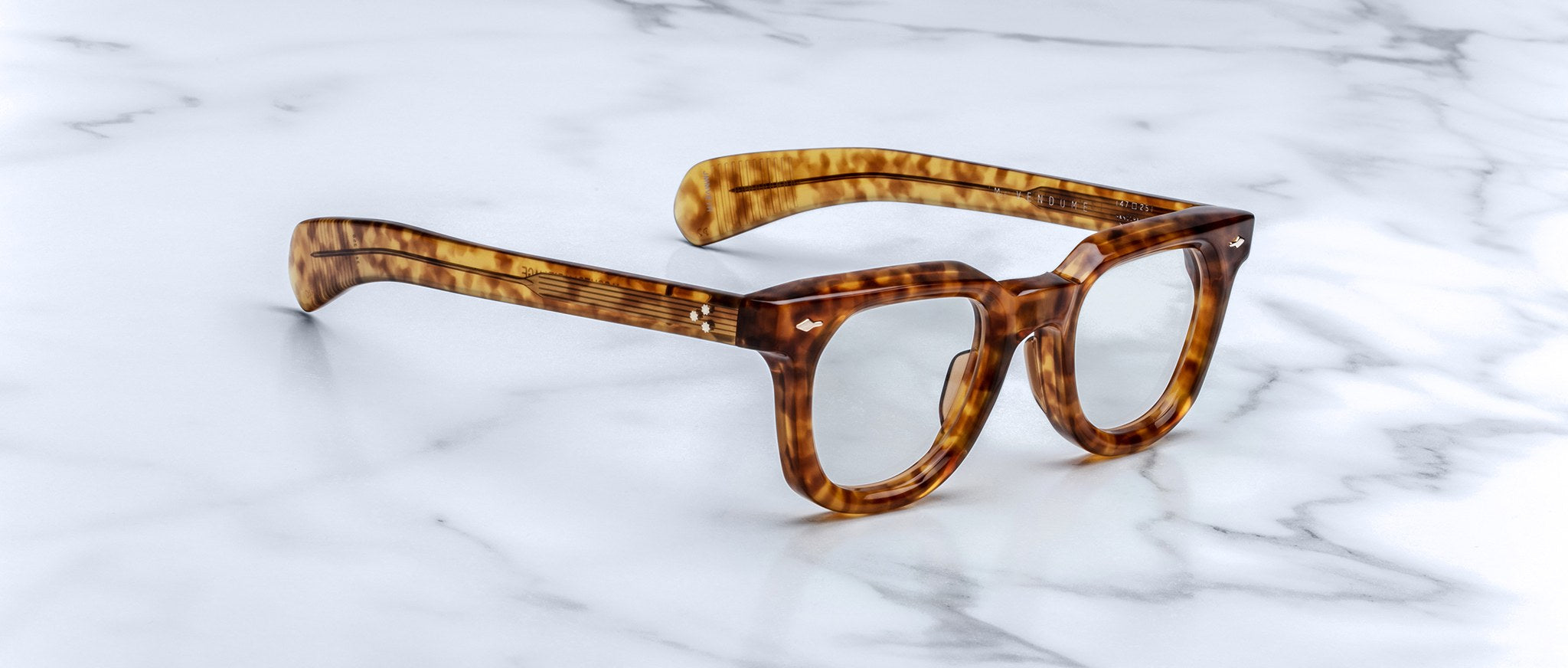 Jacques Marie Mage Vendome eyeglasses, top view, shown resting on a white marble surface.