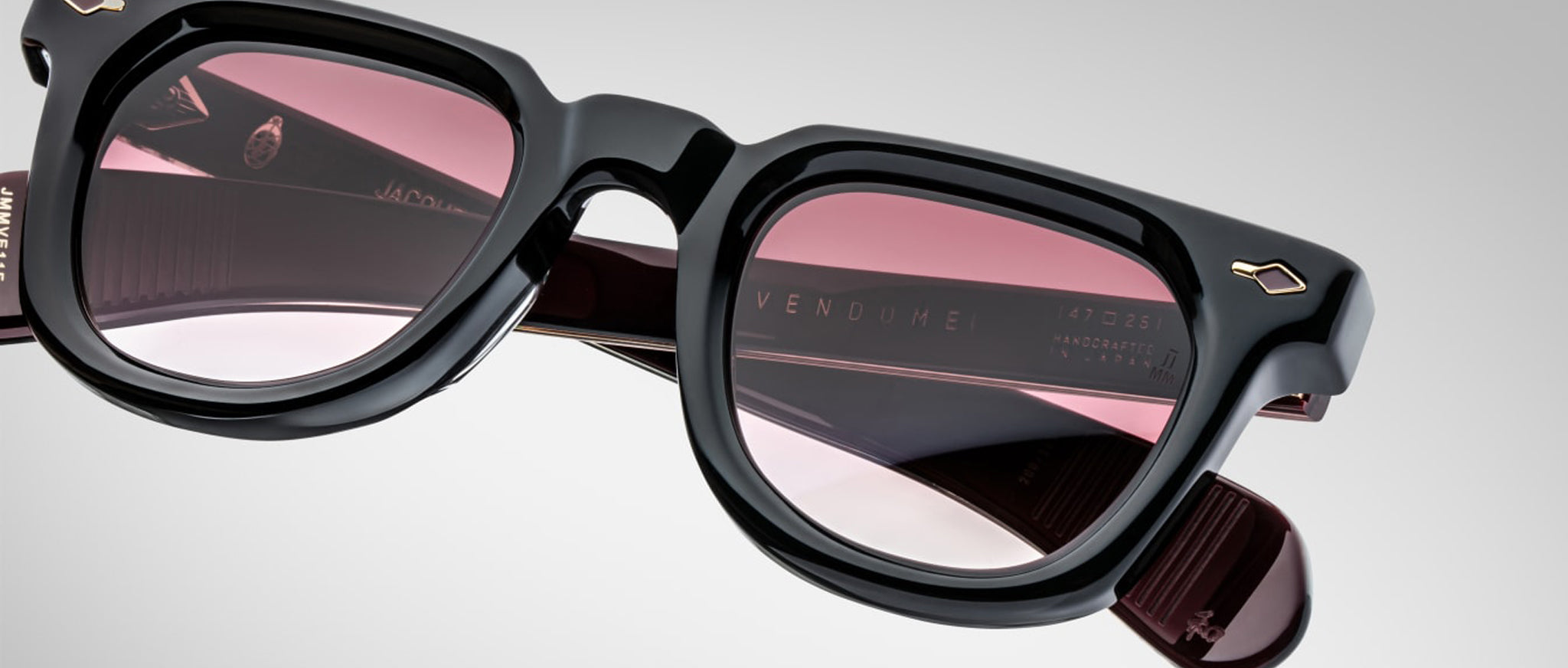 Close-up of Jacques Marie Mage Vendome black sunglasses with pink lenses, viewed from the front.